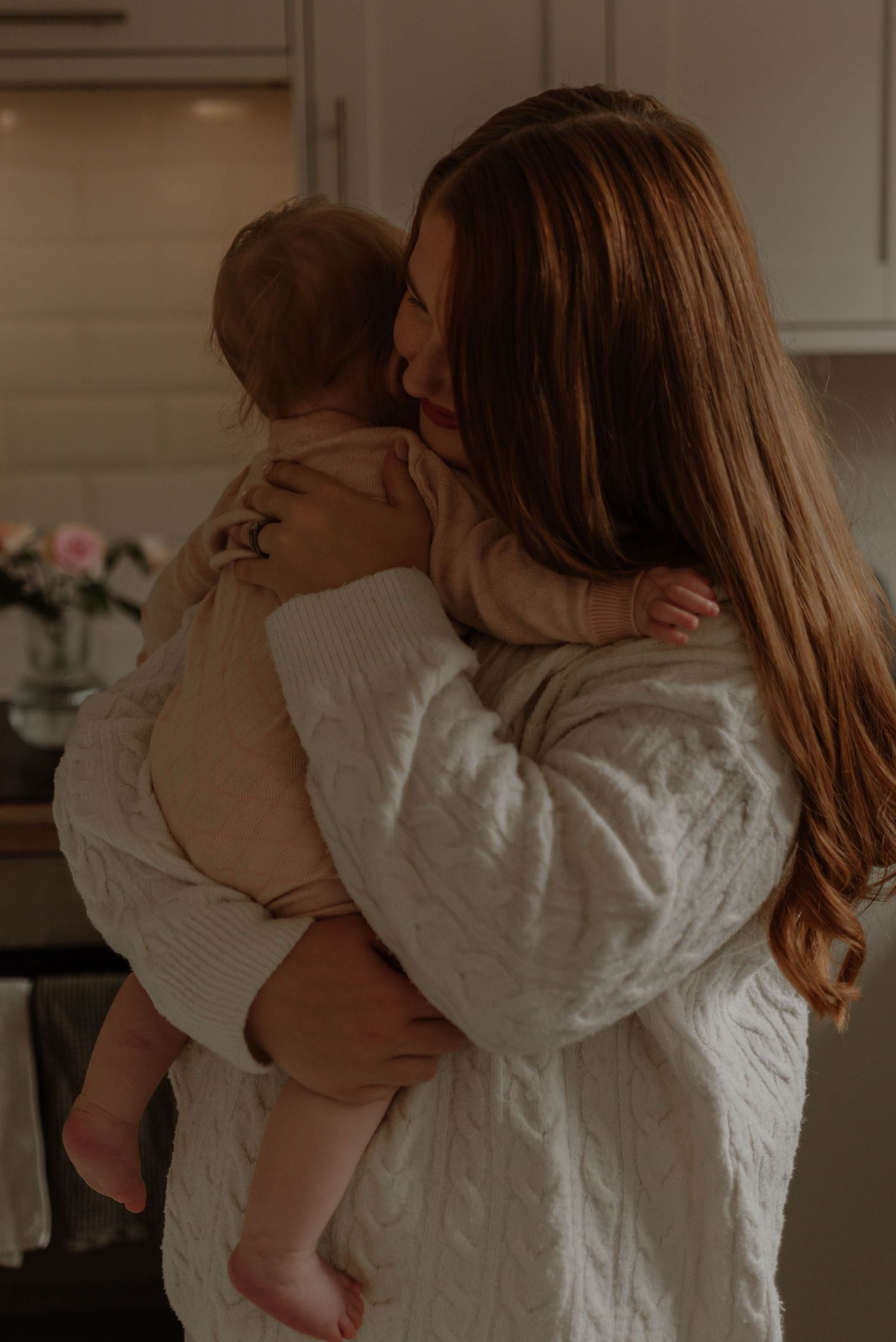 A series of tender moments showing a parent in white embracing a small child against a warm interior background.
