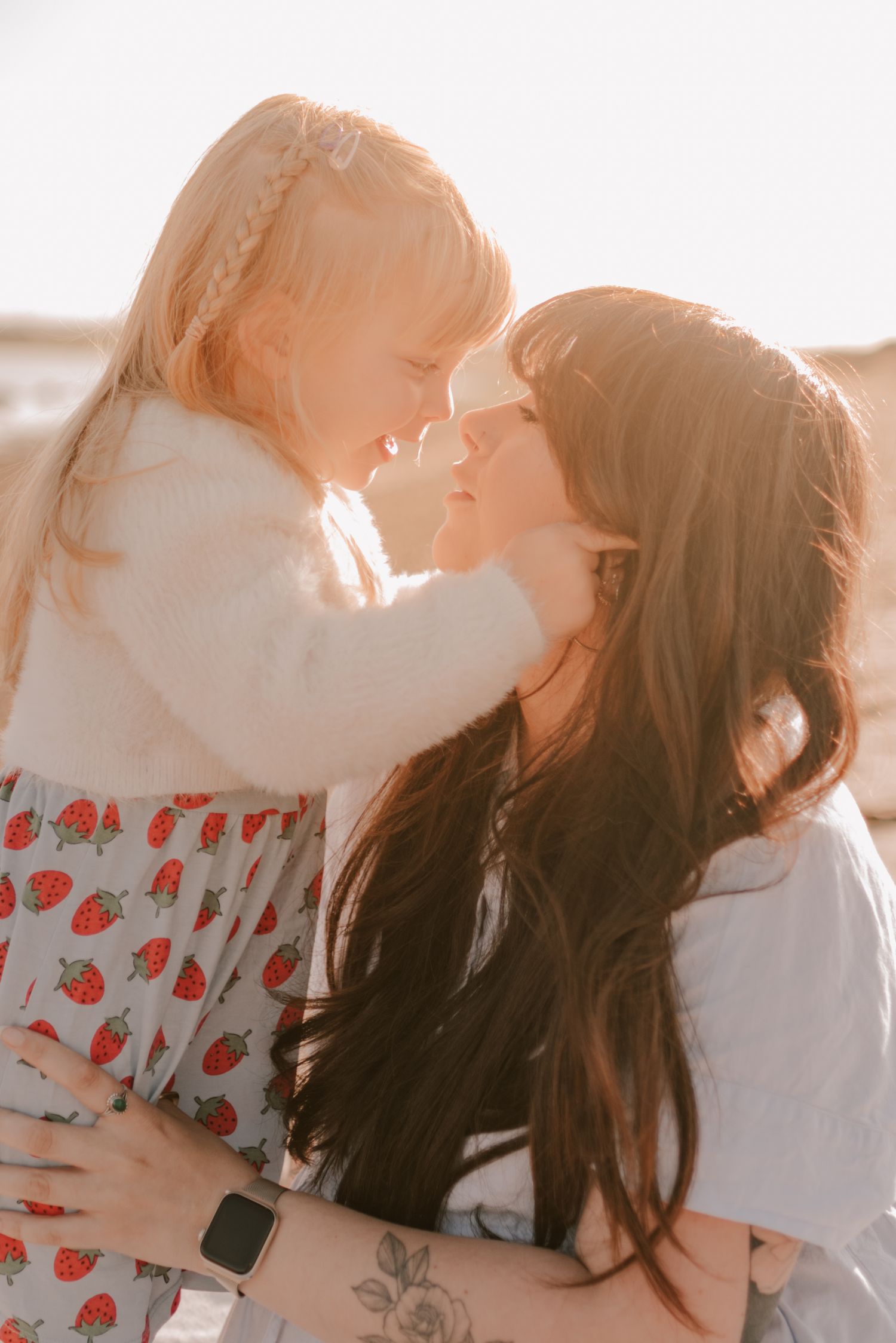 A tender parent-child moment with sunlight streaming through as they embrace on a bright day.