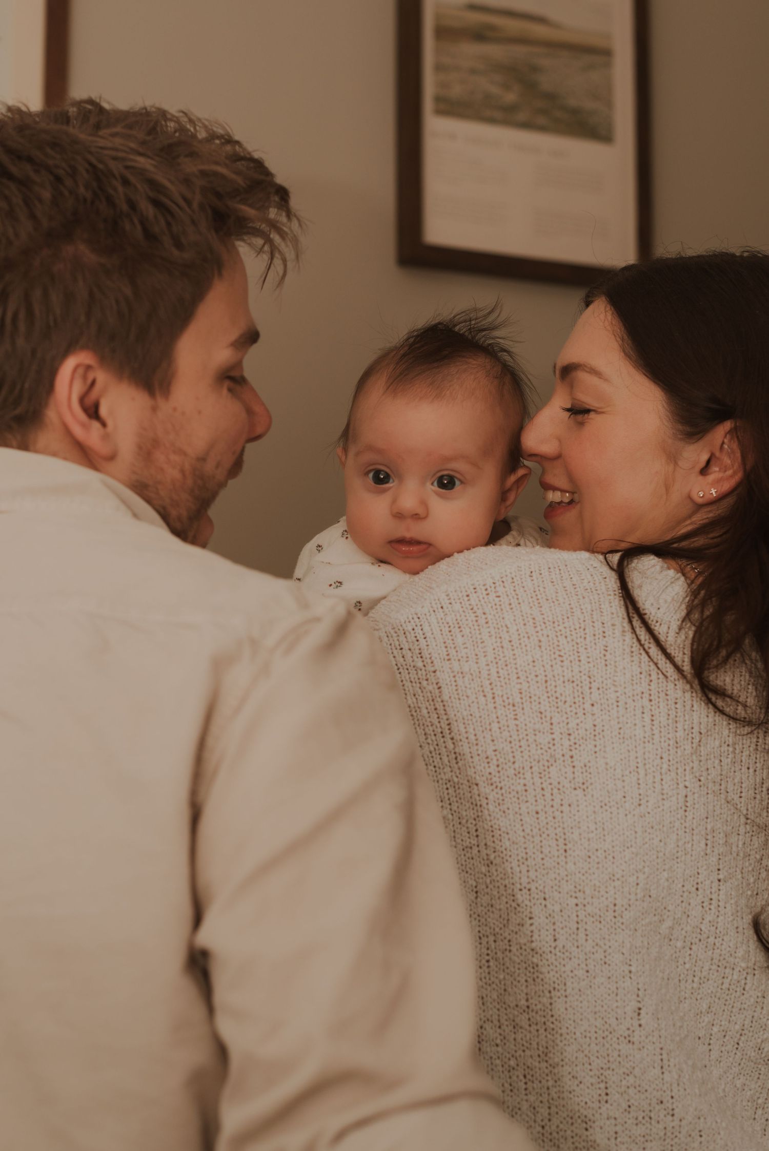 Intimate family moment captured in warm indoor lighting with neutral tones.