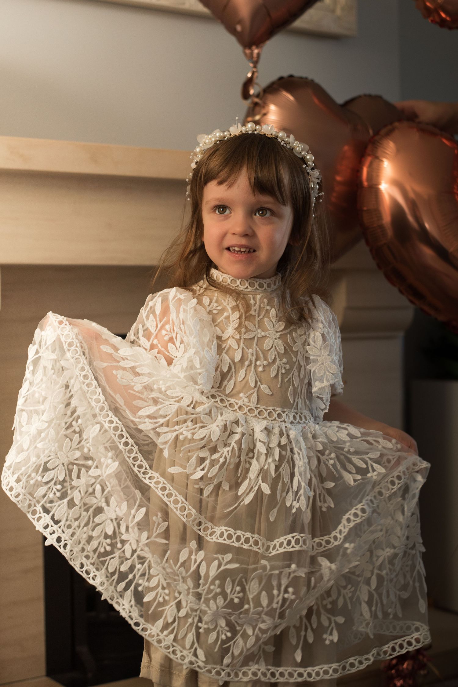 A special occasion portrait featuring an elegant white lace dress and copper balloons.