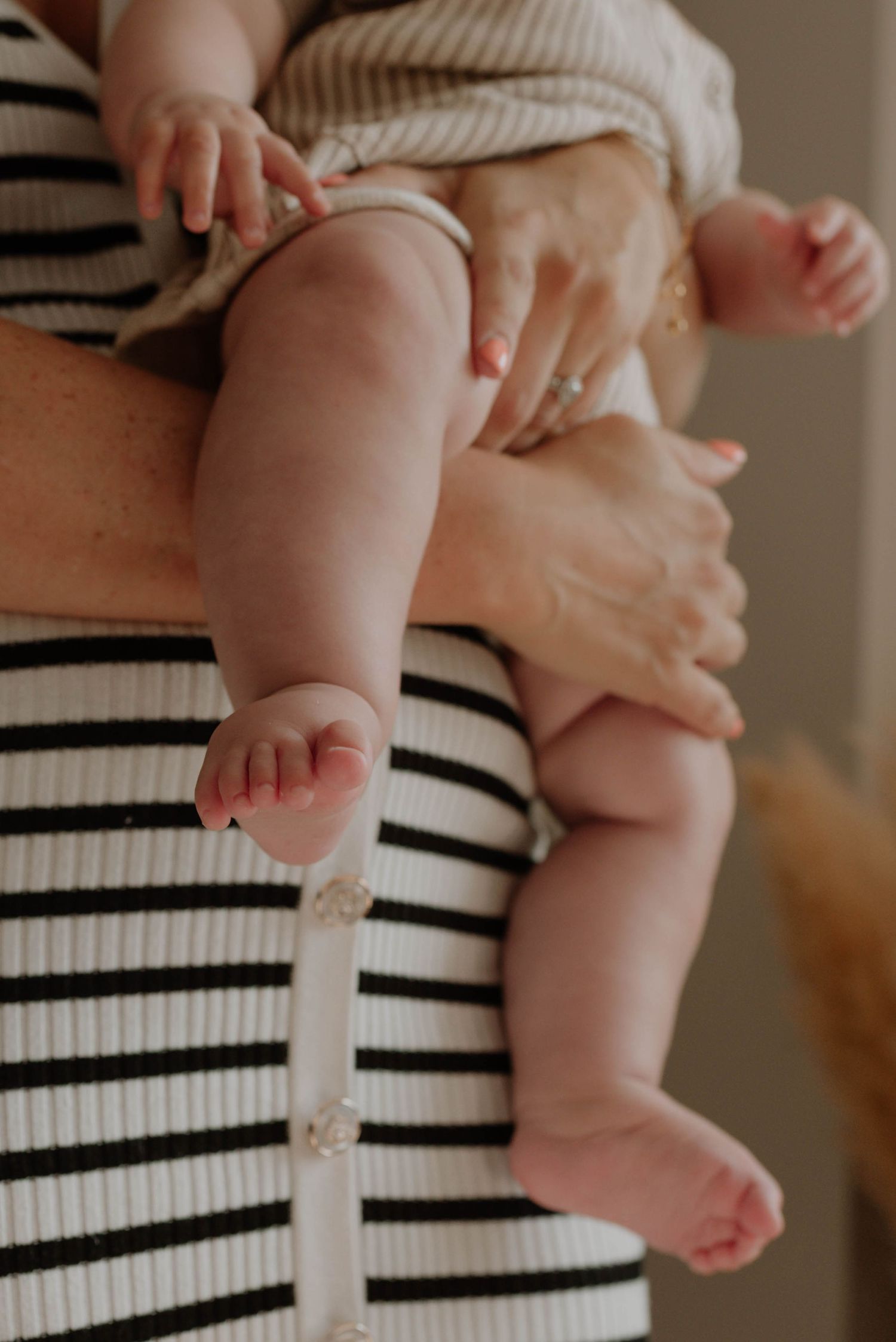 A series of close-up shots showing tiny baby feet against a black and white striped fabric background.