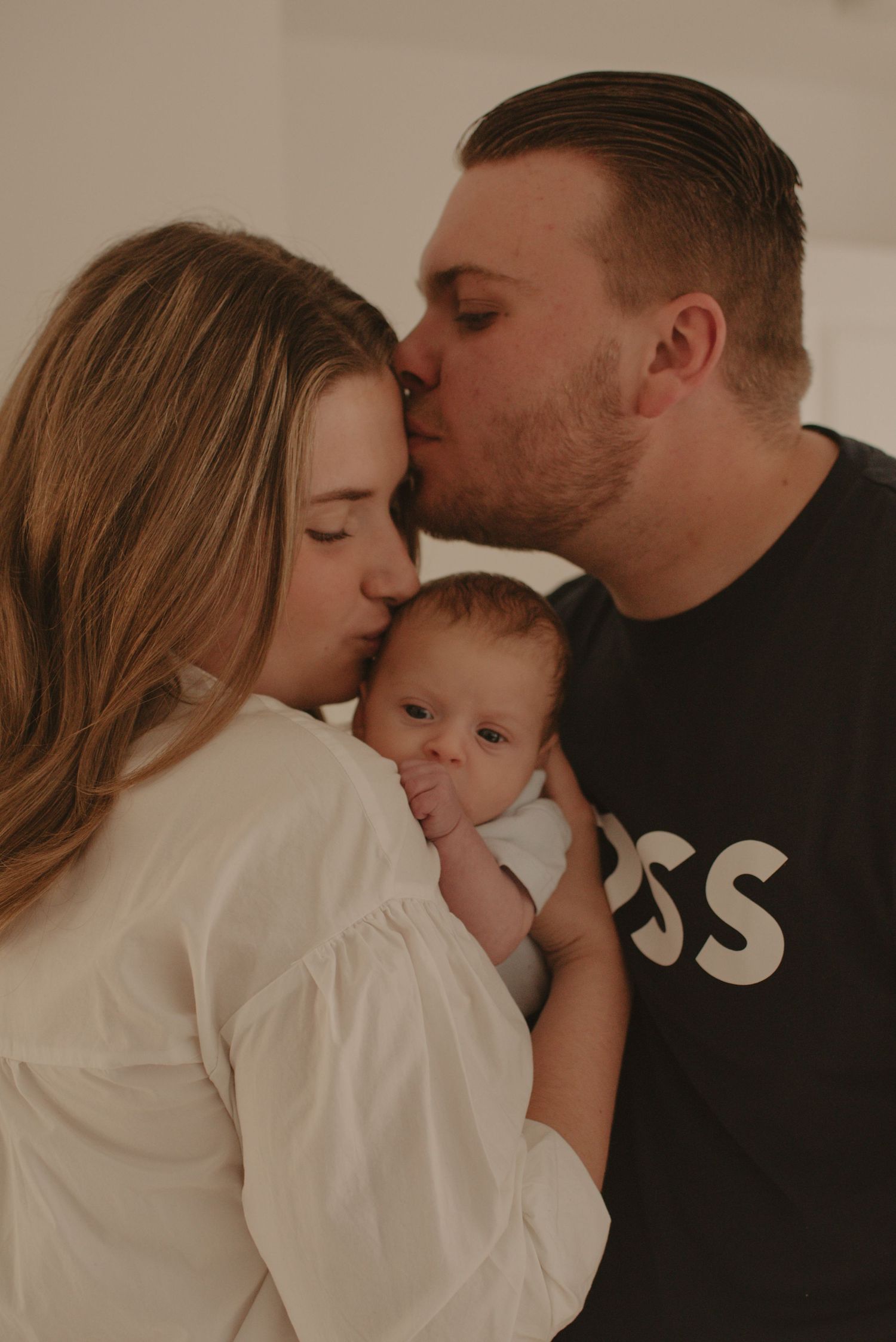 Intimate family portrait showing tender moment with new baby.