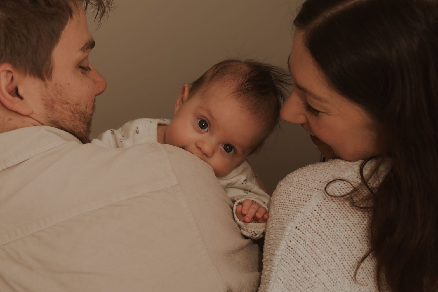 An intimate family moment captured in warm, dim lighting.