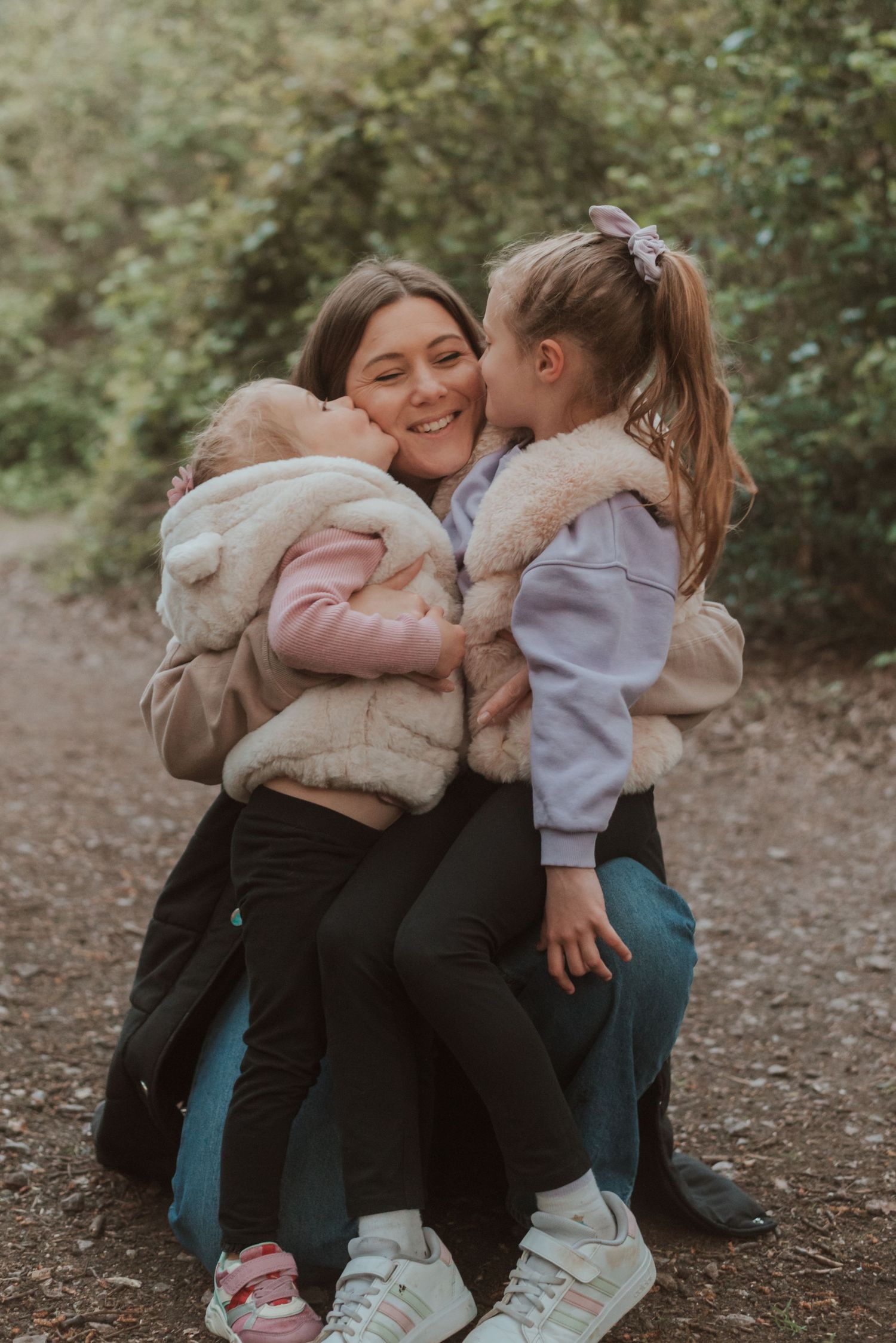 A joyful moment captured outdoors showing warm family embraces on an autumn path.