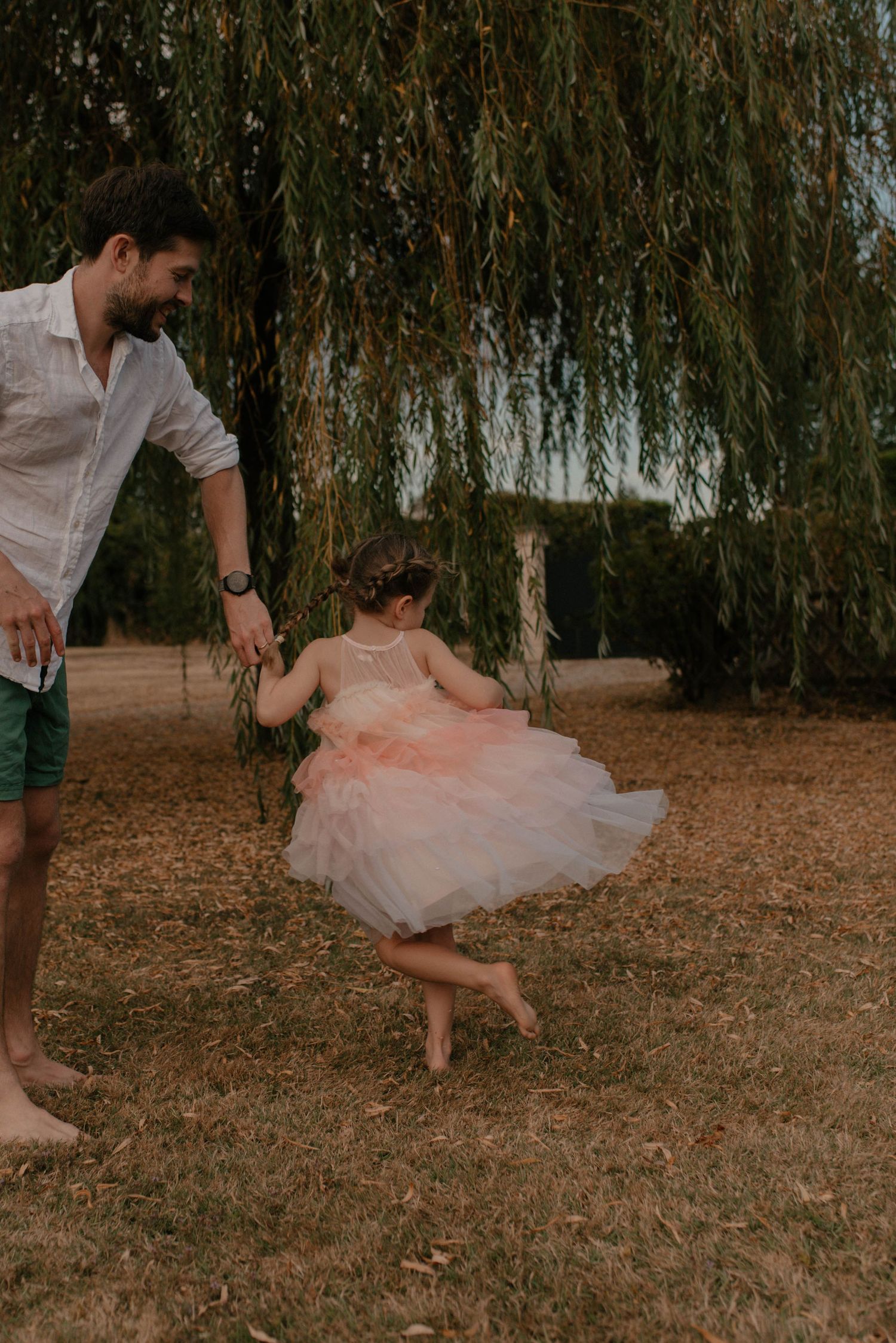A sequence of playful dance moves captured under a willow tree showing twirls in a pink tulle dress.