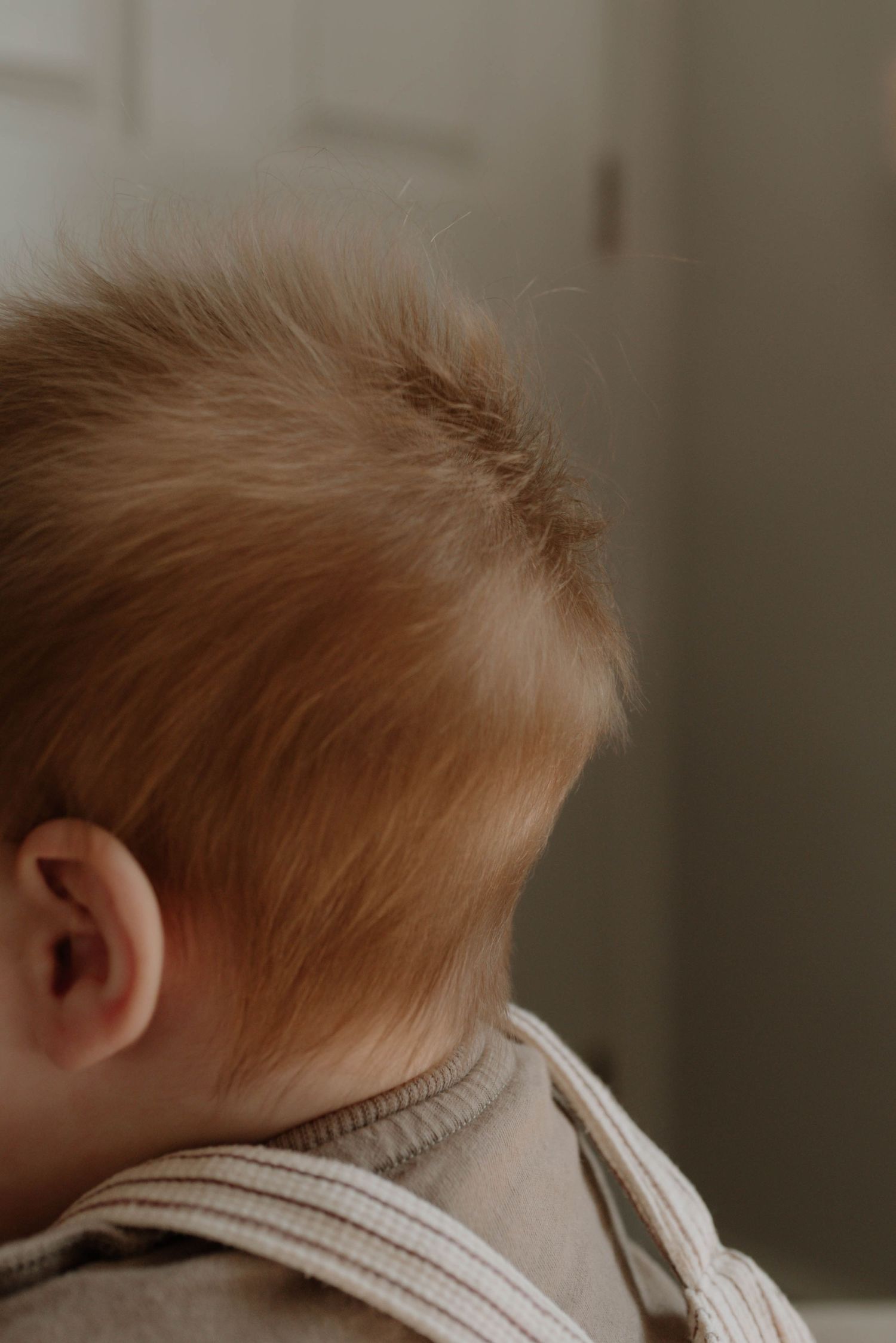 Close-up series of a baby's head showing soft ginger hair from different angles in natural light.