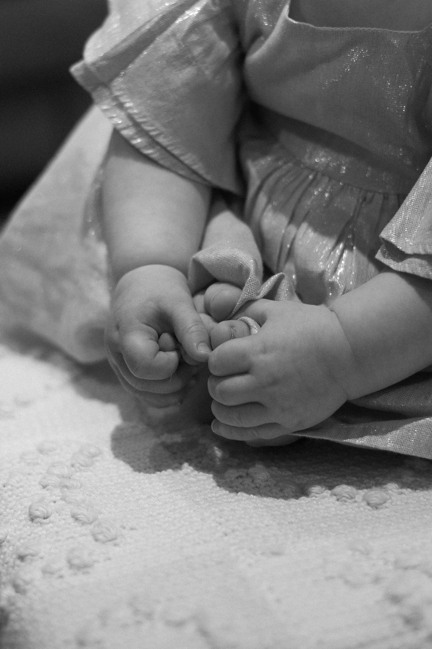 Close-up of tiny bare feet on a textured white surface.