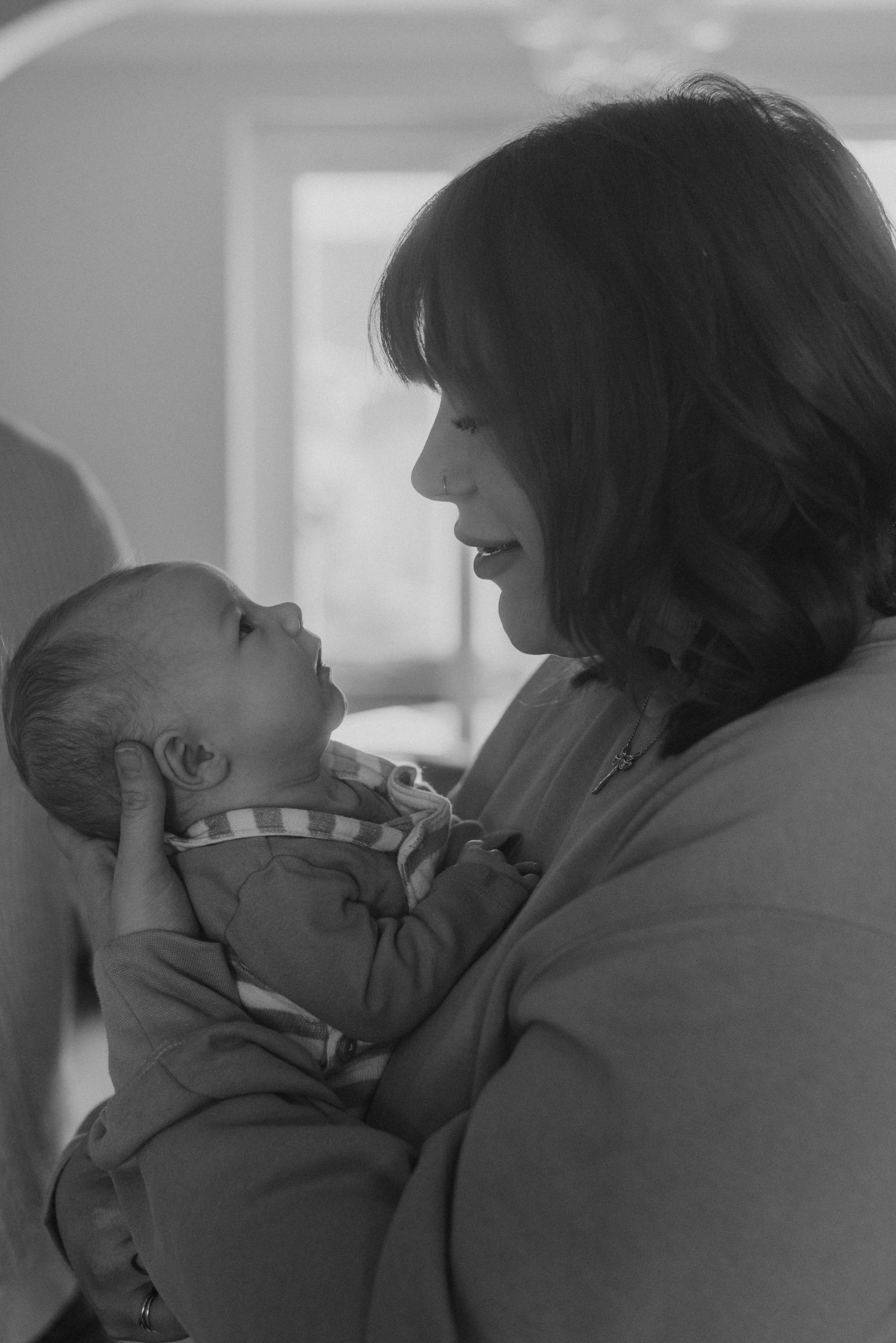 Black and white portrait of tender moments between family members and their newborn.