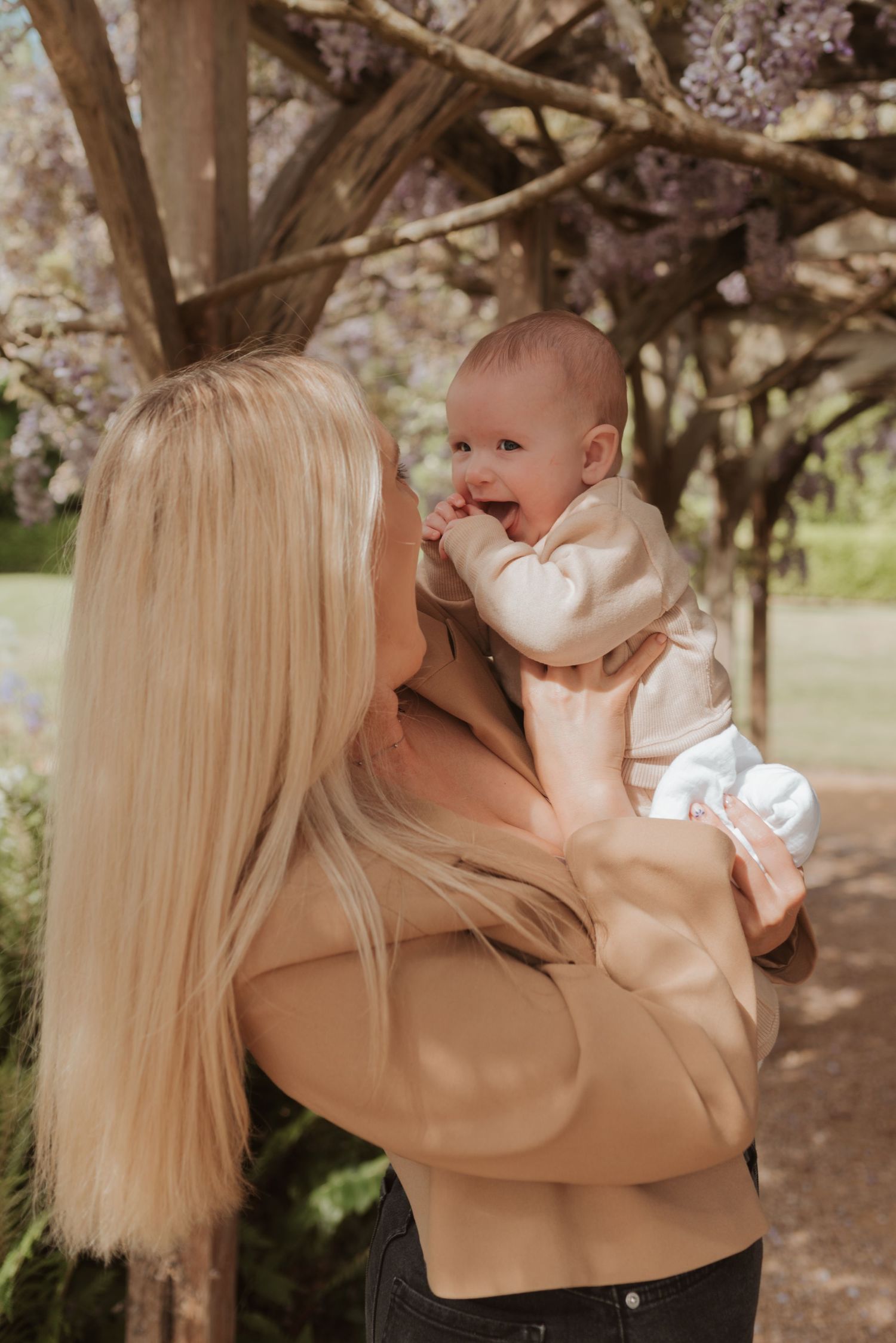Spring portrait session under blooming trees in warm earthy tones.