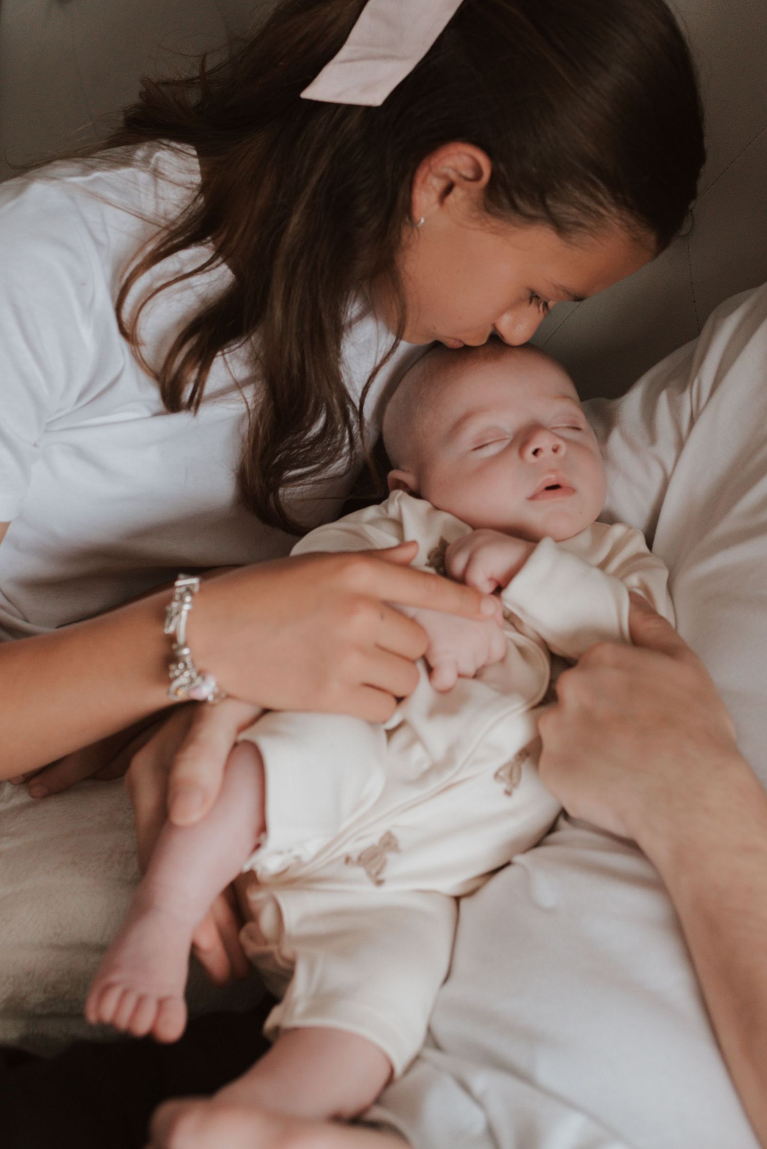 Intimate newborn photography moment captured in soft monochromatic tones.