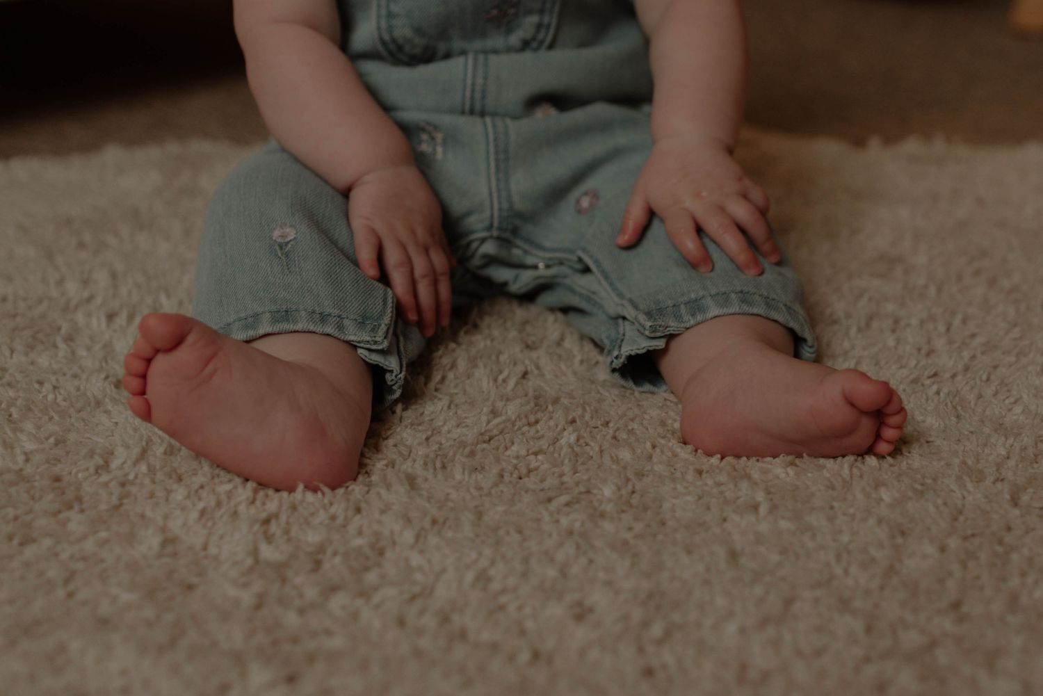 A series of baby feet and legs sitting on beige carpet showing different positions and angles.