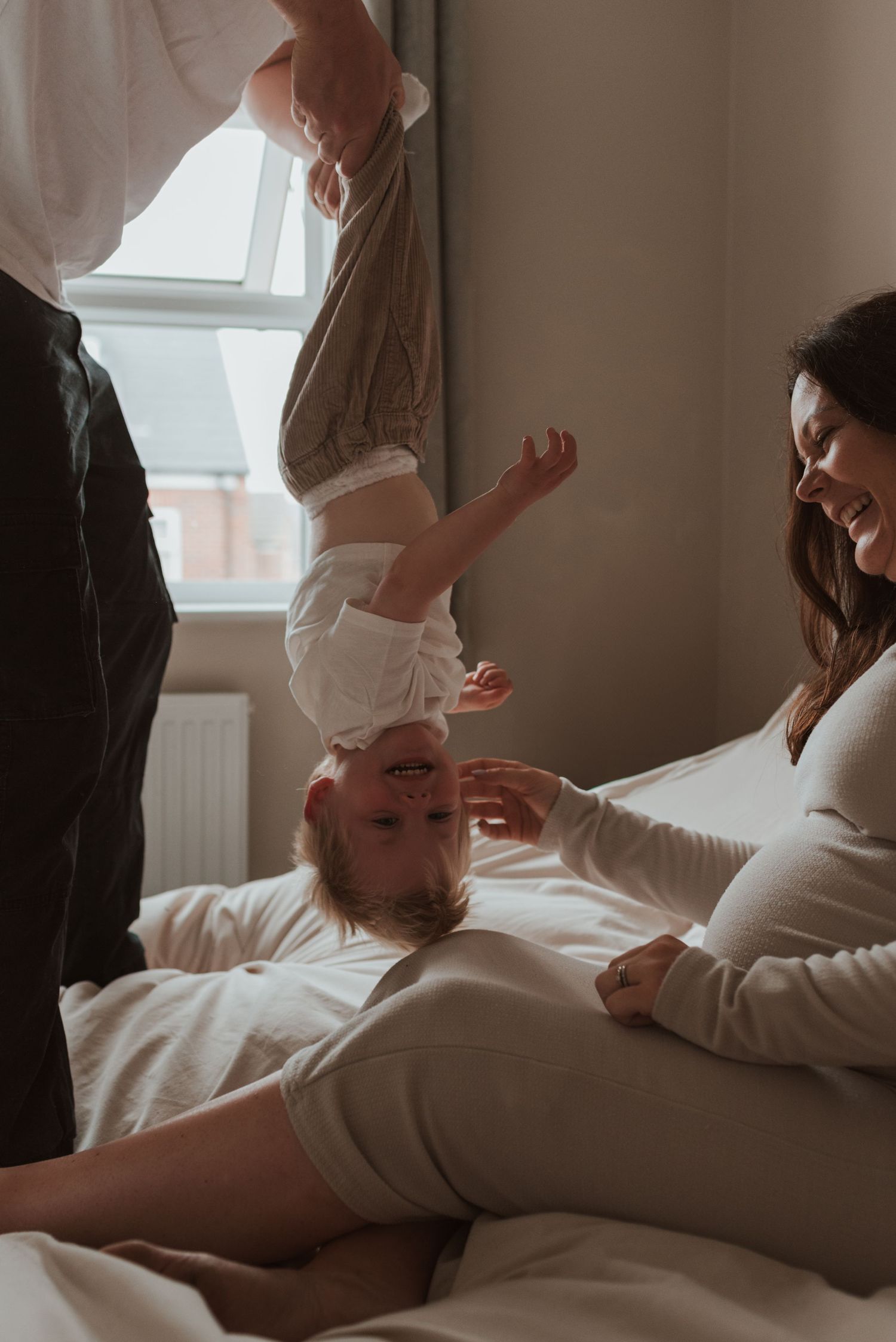 An intimate indoor maternity photoshoot showing tender moments between a couple.
