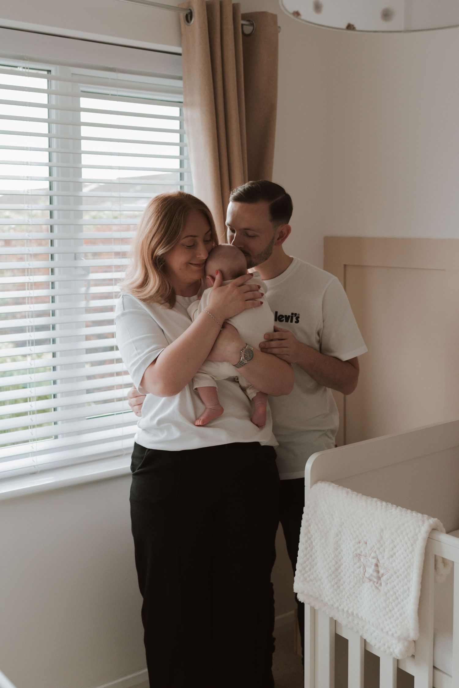 Family sharing tender moments together in a bright nursery room.