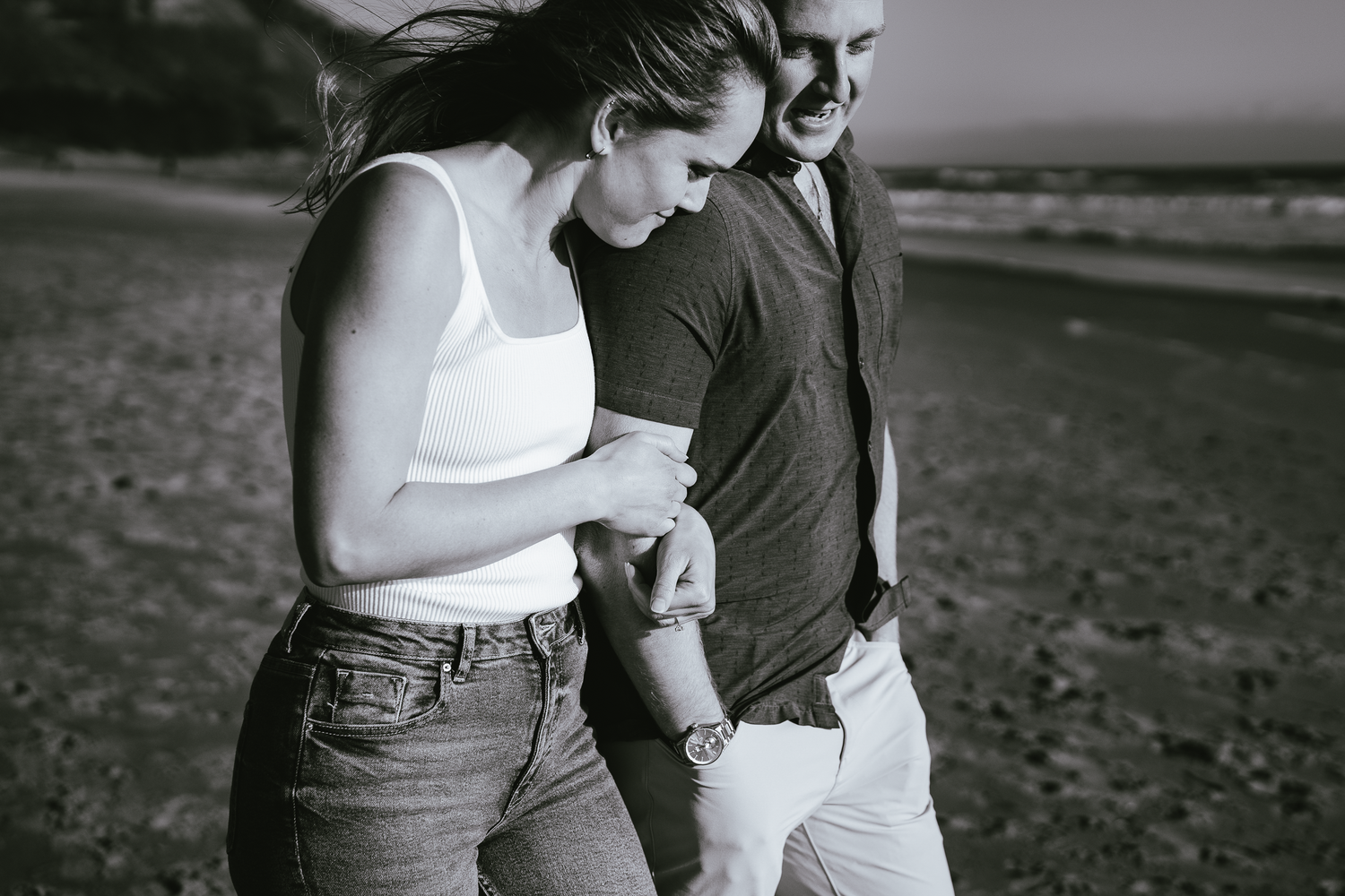 Black and white candid photos of couple walking together on Stinson Beach in Marin County.