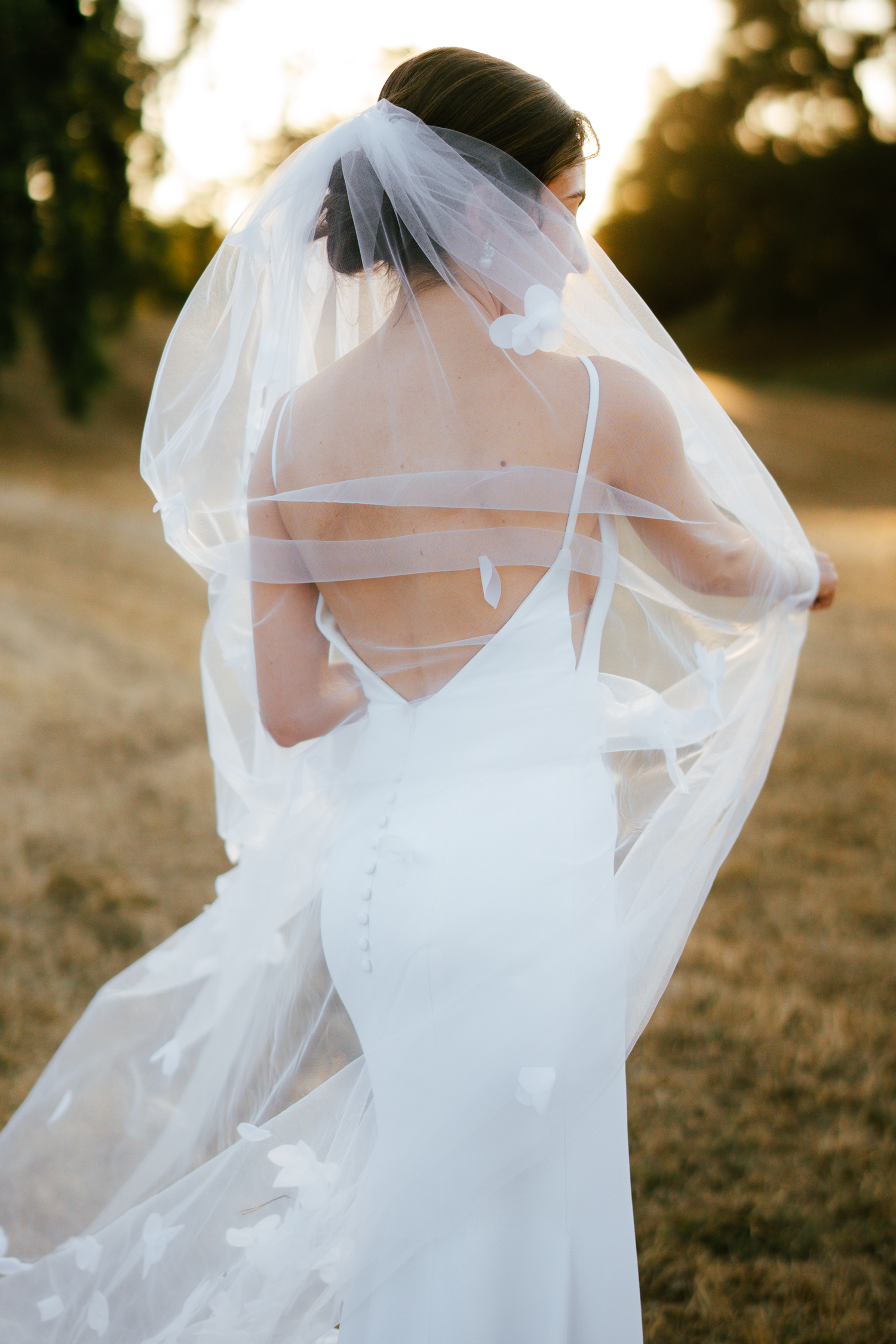 Ethereal bridal portrait showing flowing white veil and dress details in golden hour lighting at Harper's Rest in Healdsburg, California.