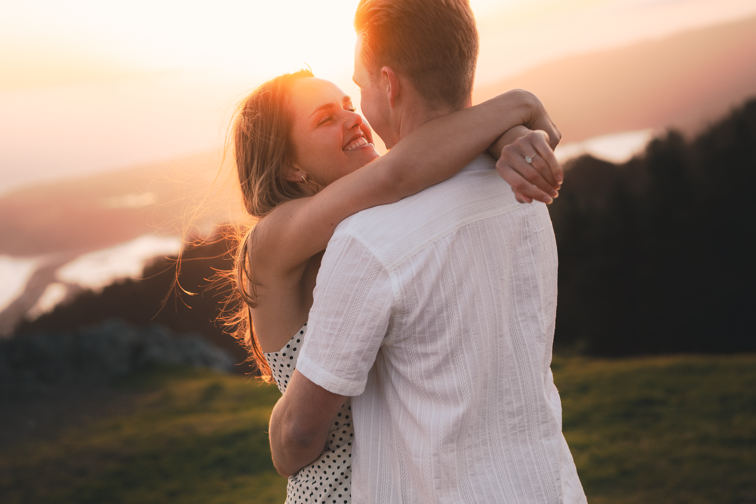 A tender embrace captured during golden hour with a scenic mountain backdrop on Mount Tamalpais in Marin County.