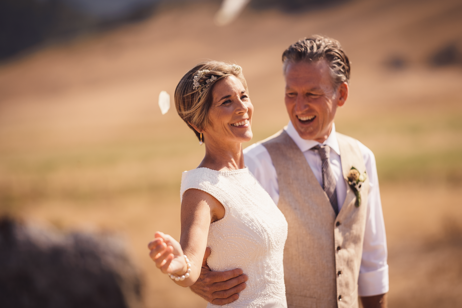 A couple shares joyful moments together in a sun-drenched field during their wedding day at Cow-Track Ranch in Marin County.