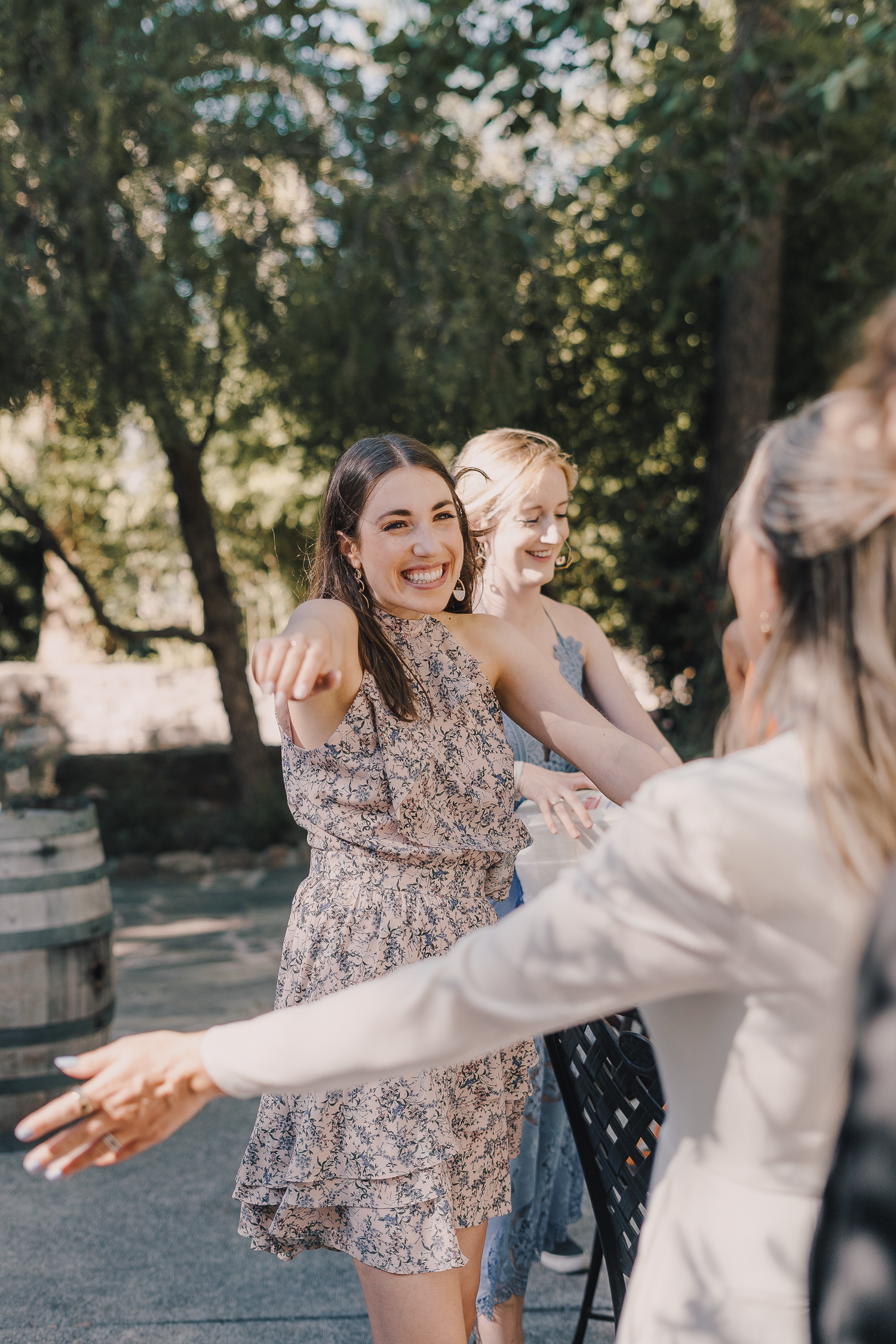 Group of wedding guests dancing and celebrating outdoors in a garden setting.