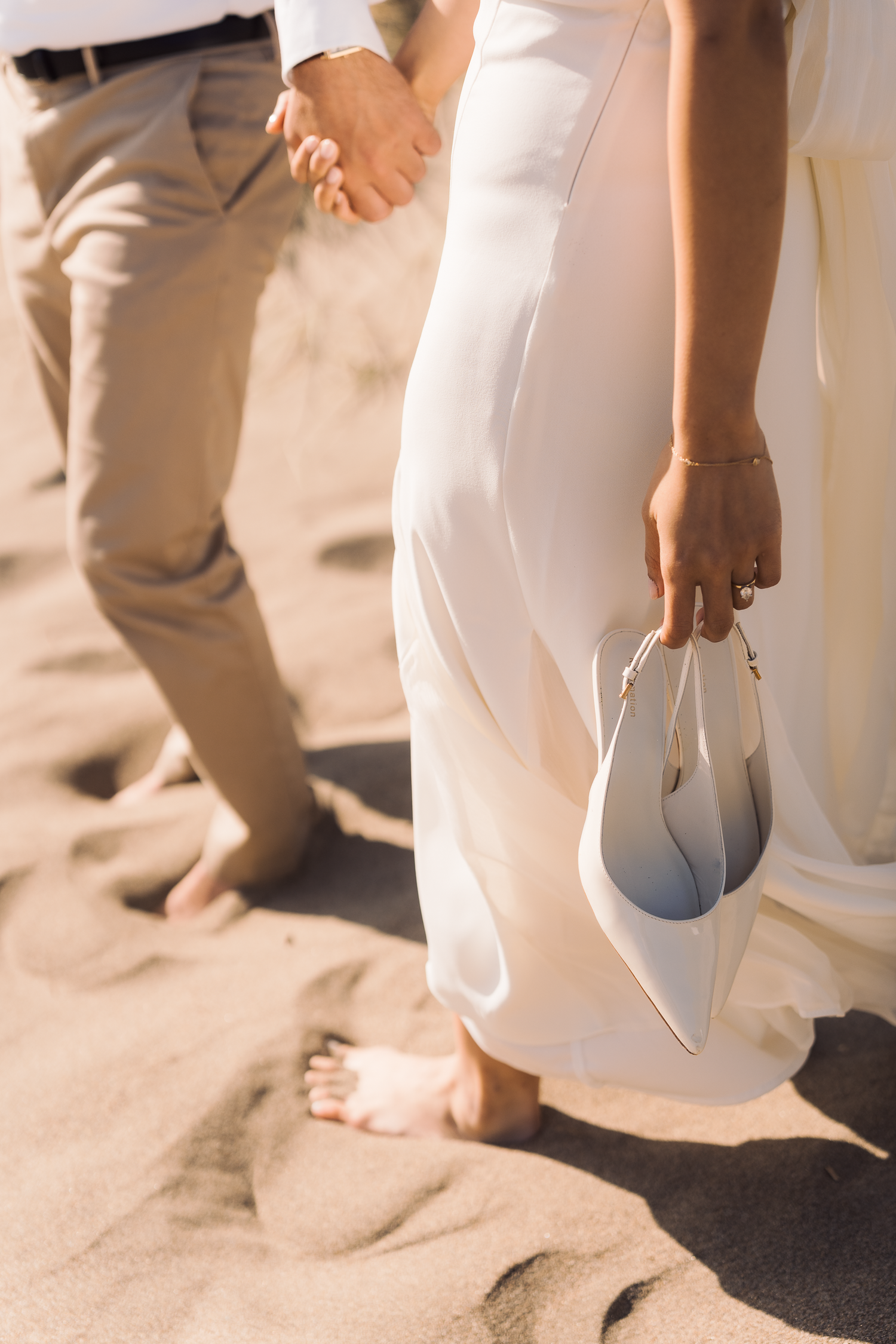 Close-up of feet walking on sandy beach during couple's photoshoot at Ocean Beach in San Francisco.