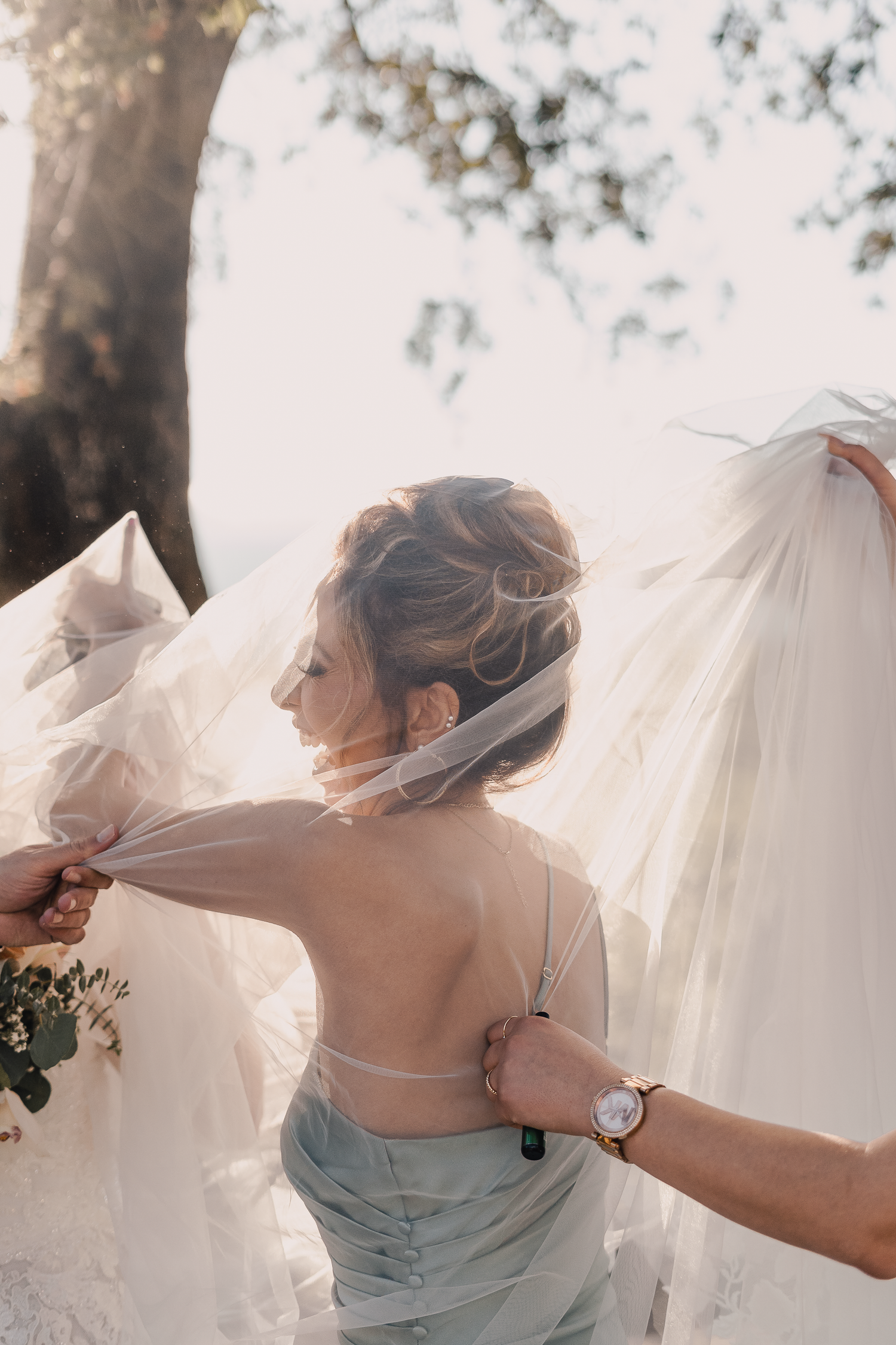 Artistic wedding photos showing bride's dress flowing in sunlit outdoor setting.