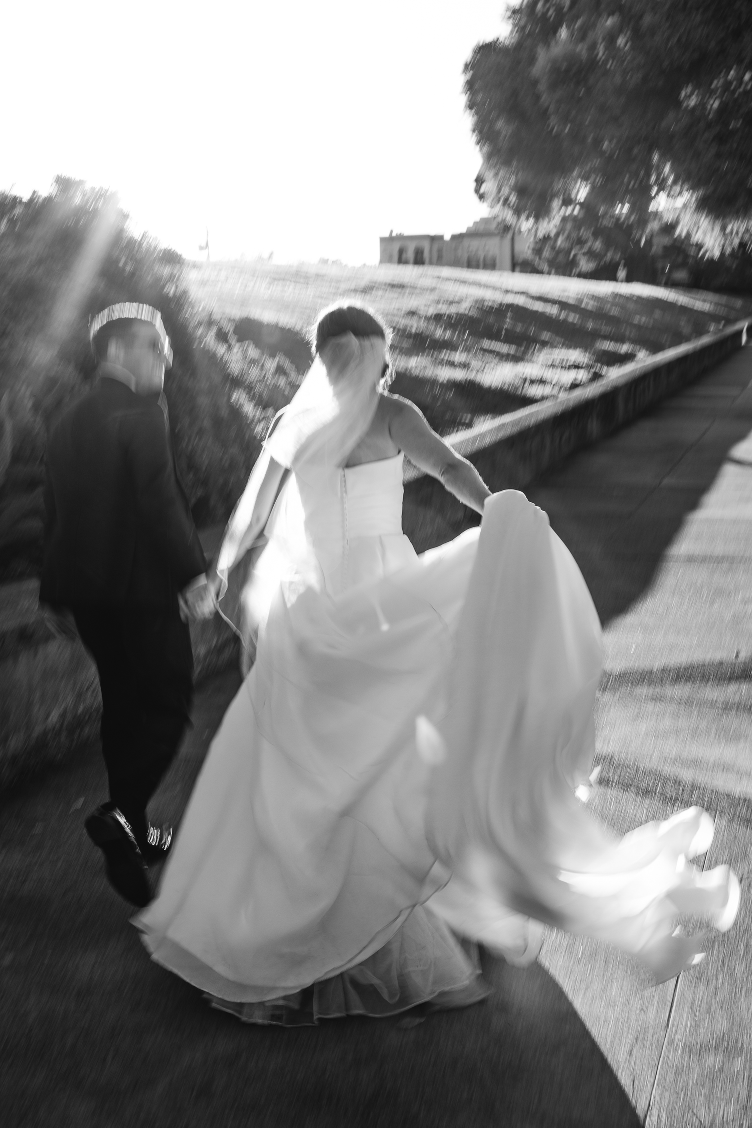 A black and white series captures a couple's playful running movements on their wedding day in San Francisco.