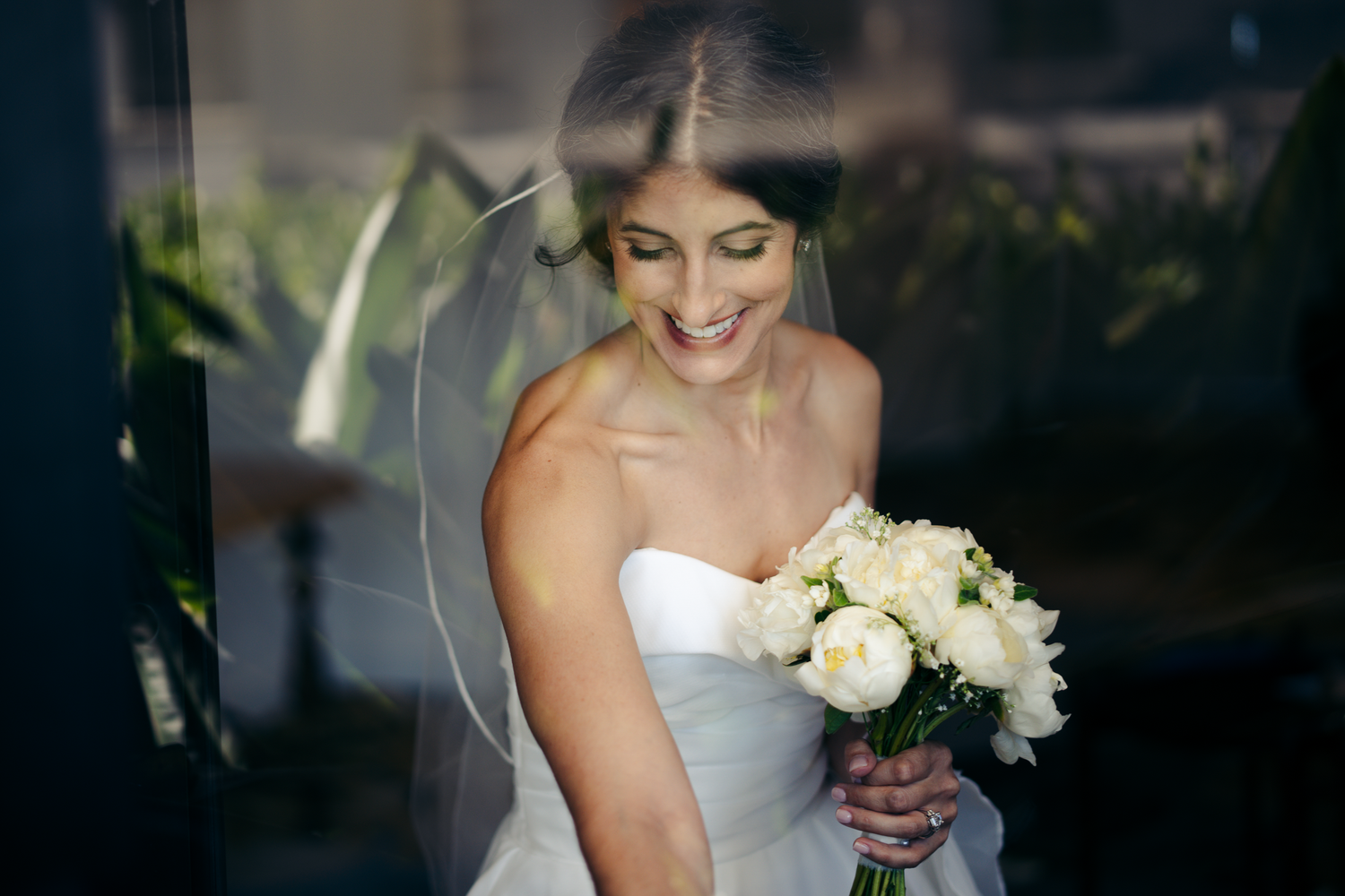 A bride holds a classic white rose bouquet during wedding preparations in San Francisco, California.