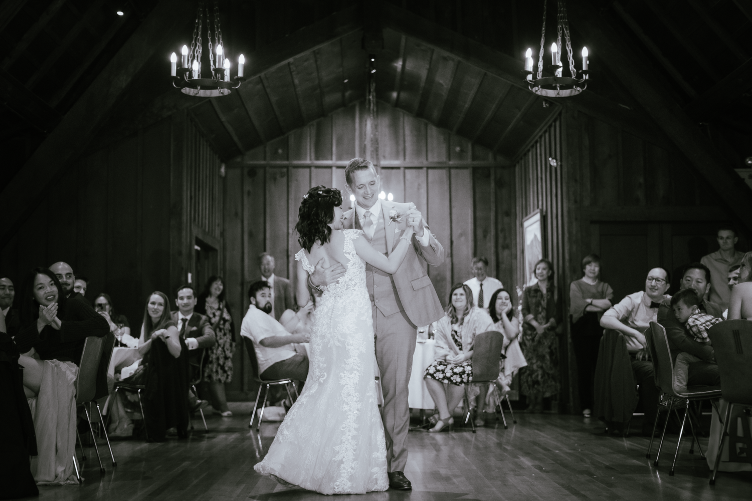 Black and white photos showing a wedding reception with dancing and celebrations in an elegant indoor venue.