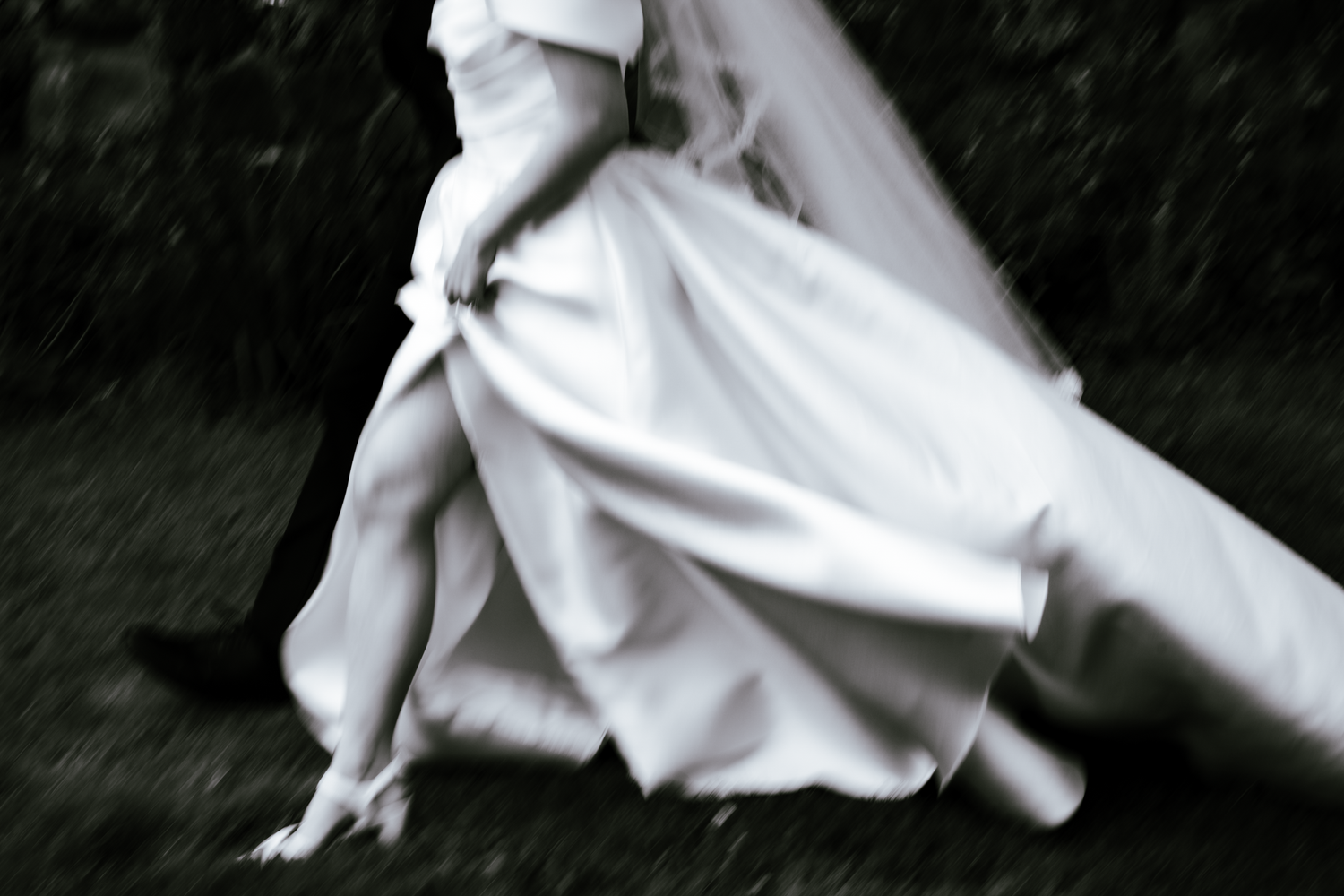 Blurry Black and White photo of Bride walking in dress with groom after the ceremony in San Francisco, California.