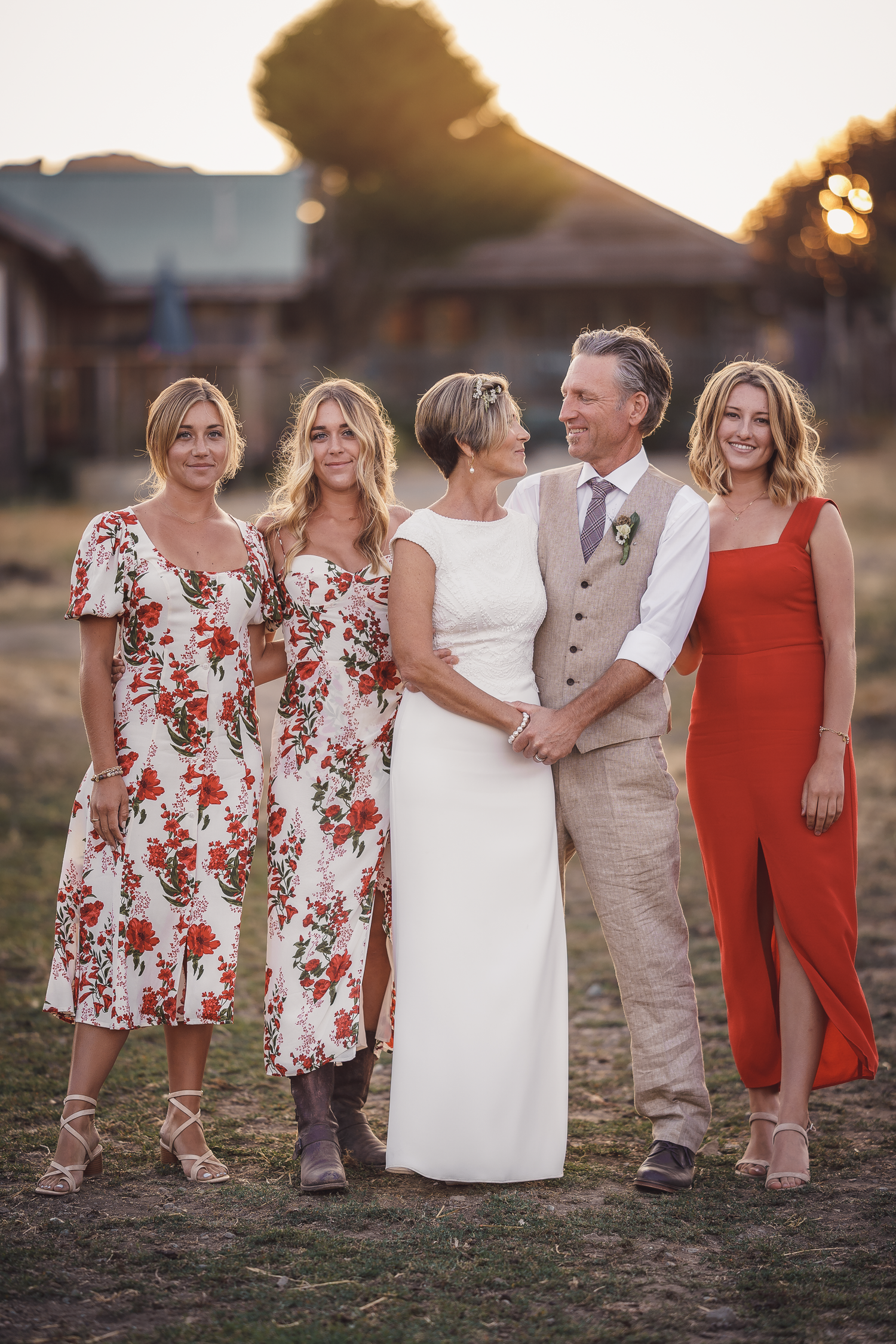 Wedding party poses together in coordinated red floral and white outfits during sunset at Cow-Track Ranch in Marin County.