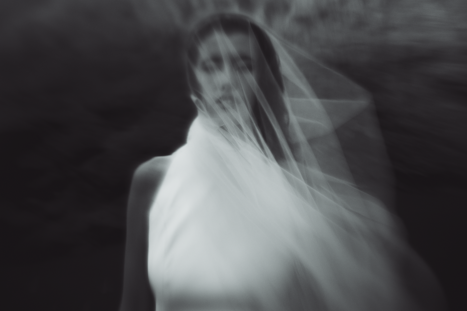 Artistic black and white portrait of bride with flowing veil at a beach in the Marin County Headlands.