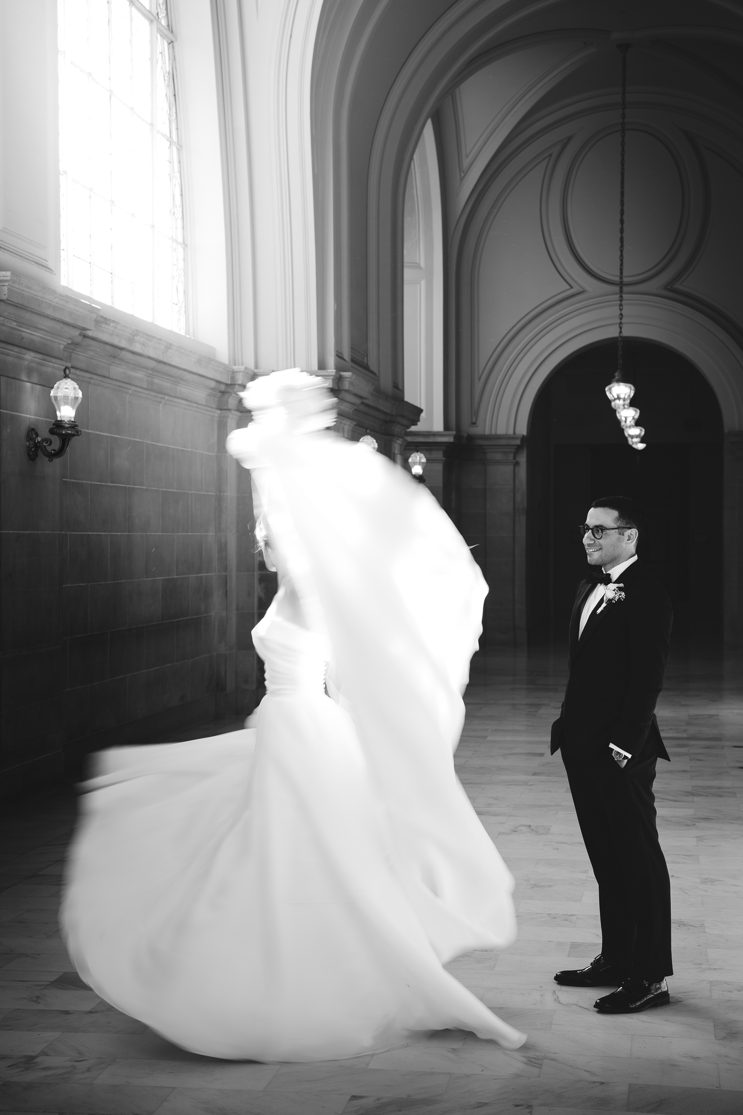 A dramatic black and white sequence shows a bride's dress flowing through an elegant hallway at SF City Hall.