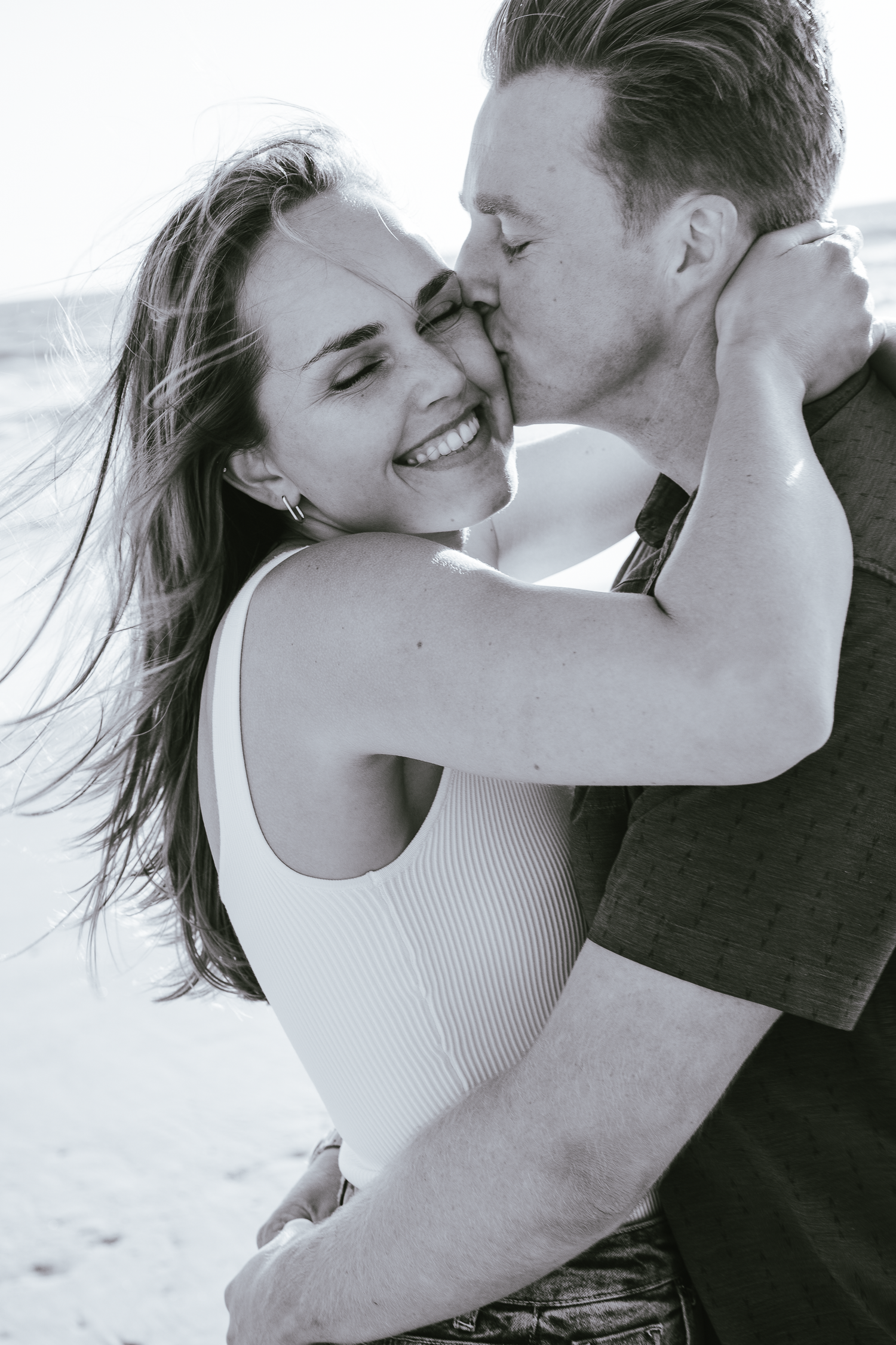 Black and white beach portraits capturing intimate moments between couple at Stinson Beach in Marin County.