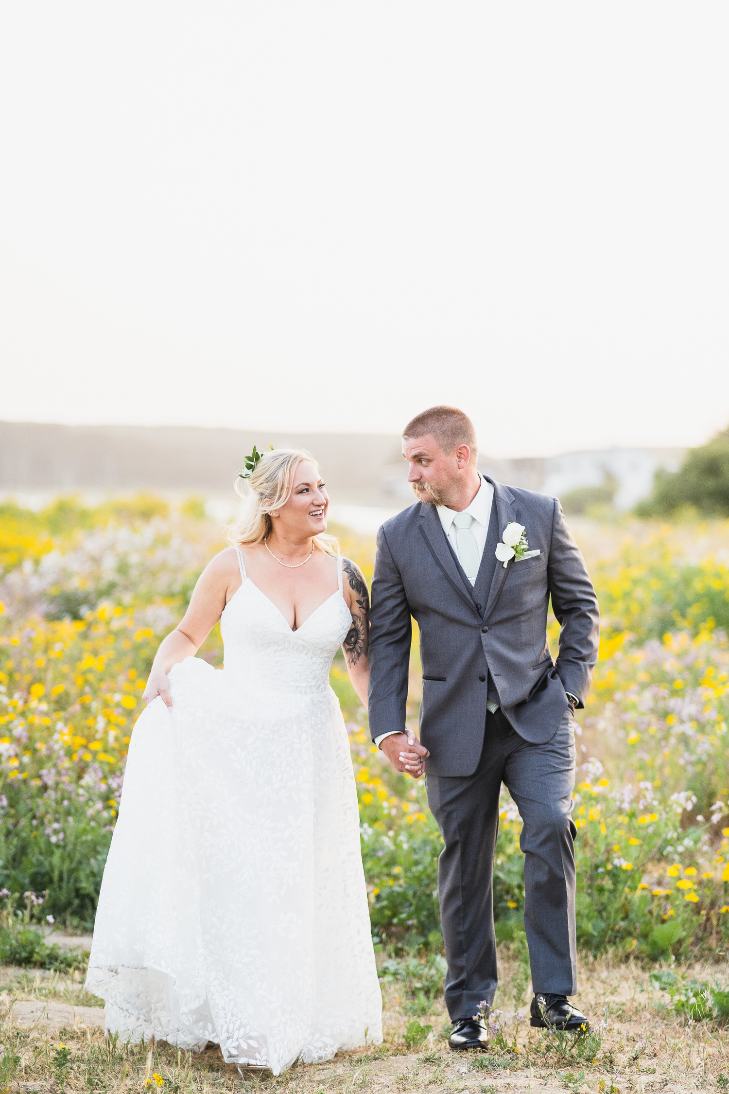 Newlyweds walk through a field of wildflowers during their wedding photo session at Oceana Hotel and Spa in Half Moon Bay.