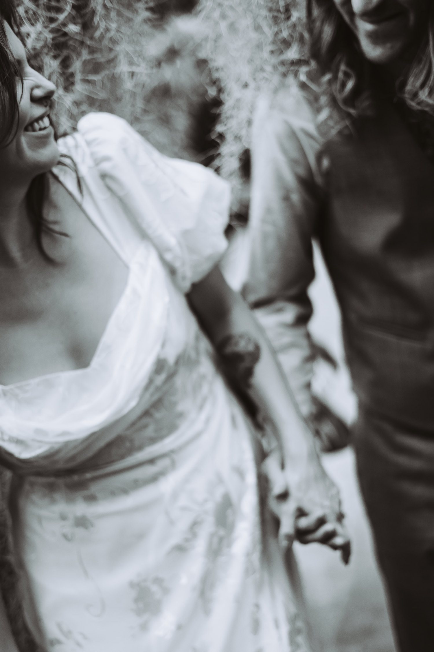 An artistic black and white engagement photo showing a flowing white dress in motion at Shelldance Orchid Farm in Pacifica.