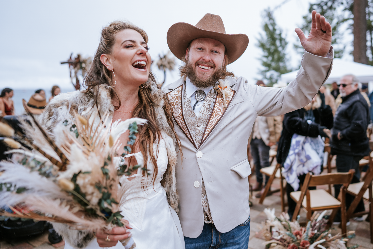 A joyous outdoor wedding celebration with bride and groom during recessional, laughing in a rustic forest setting in Lake Tahoe, California.