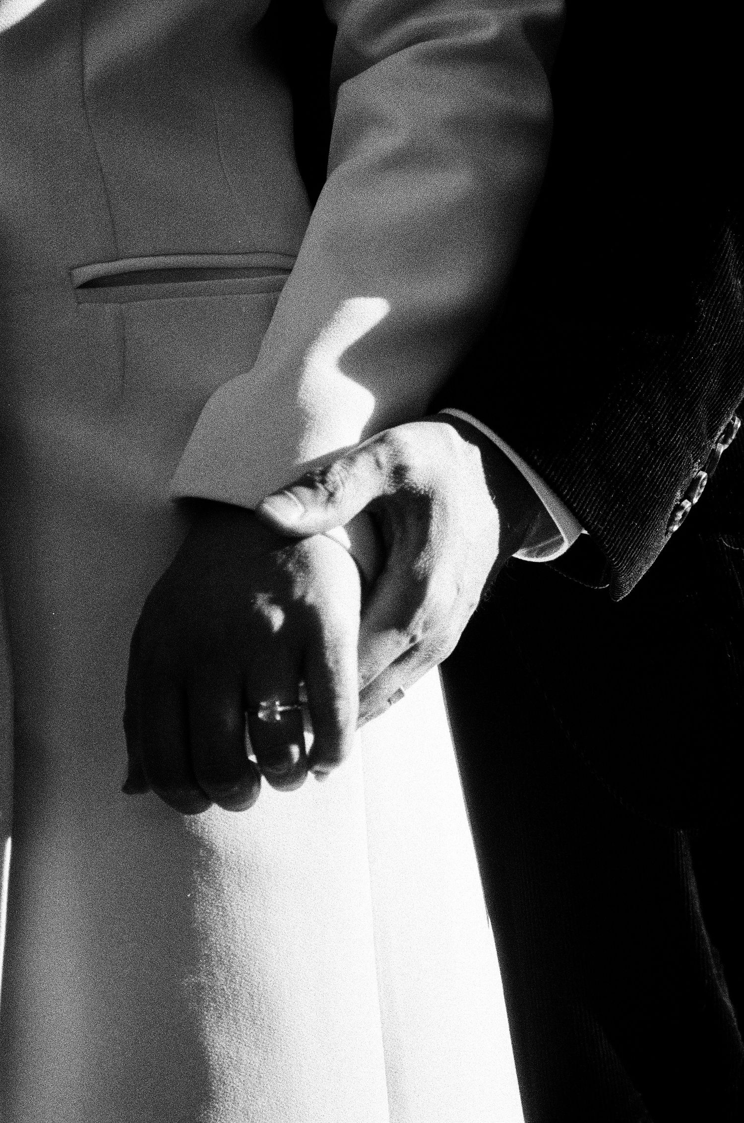 Intimate black and white photo of clasped hands with wedding rings. Photographed on film in the North Bay