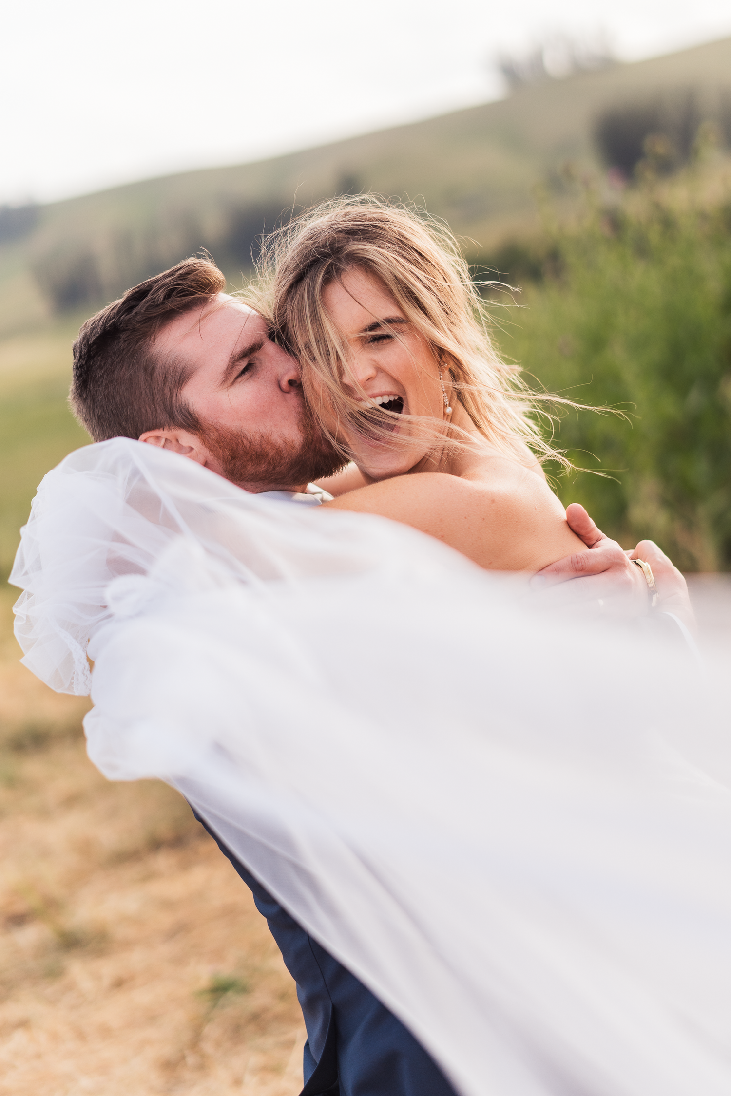 Newlyweds sharing a romantic embrace in a sunlit field at Olympia's Valley Estate in Petaluma.