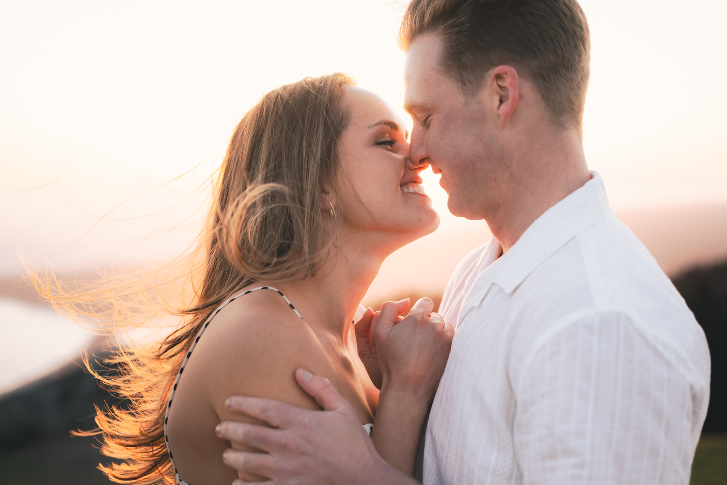 An intimate moment shared between a couple during sunset with warm golden lighting on Mount Tamalpais in Marin County.