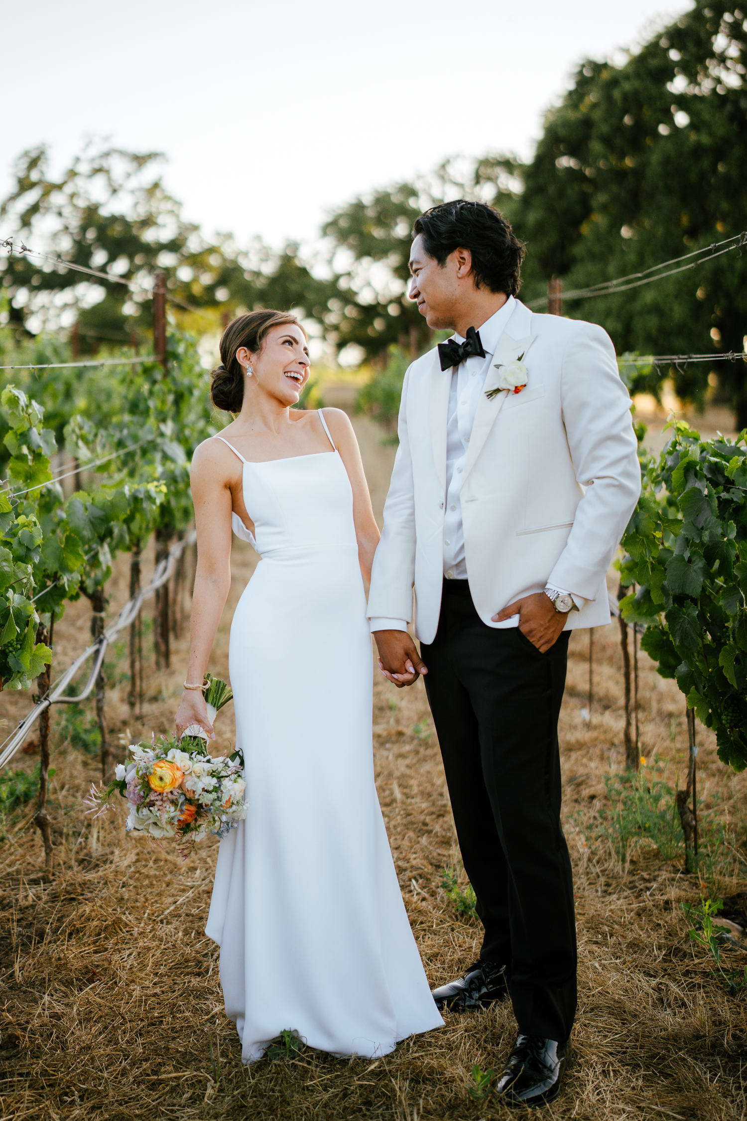 Newlyweds sharing a joyful moment together in a vineyard setting at Harper's Rest in Healdsburg, California.