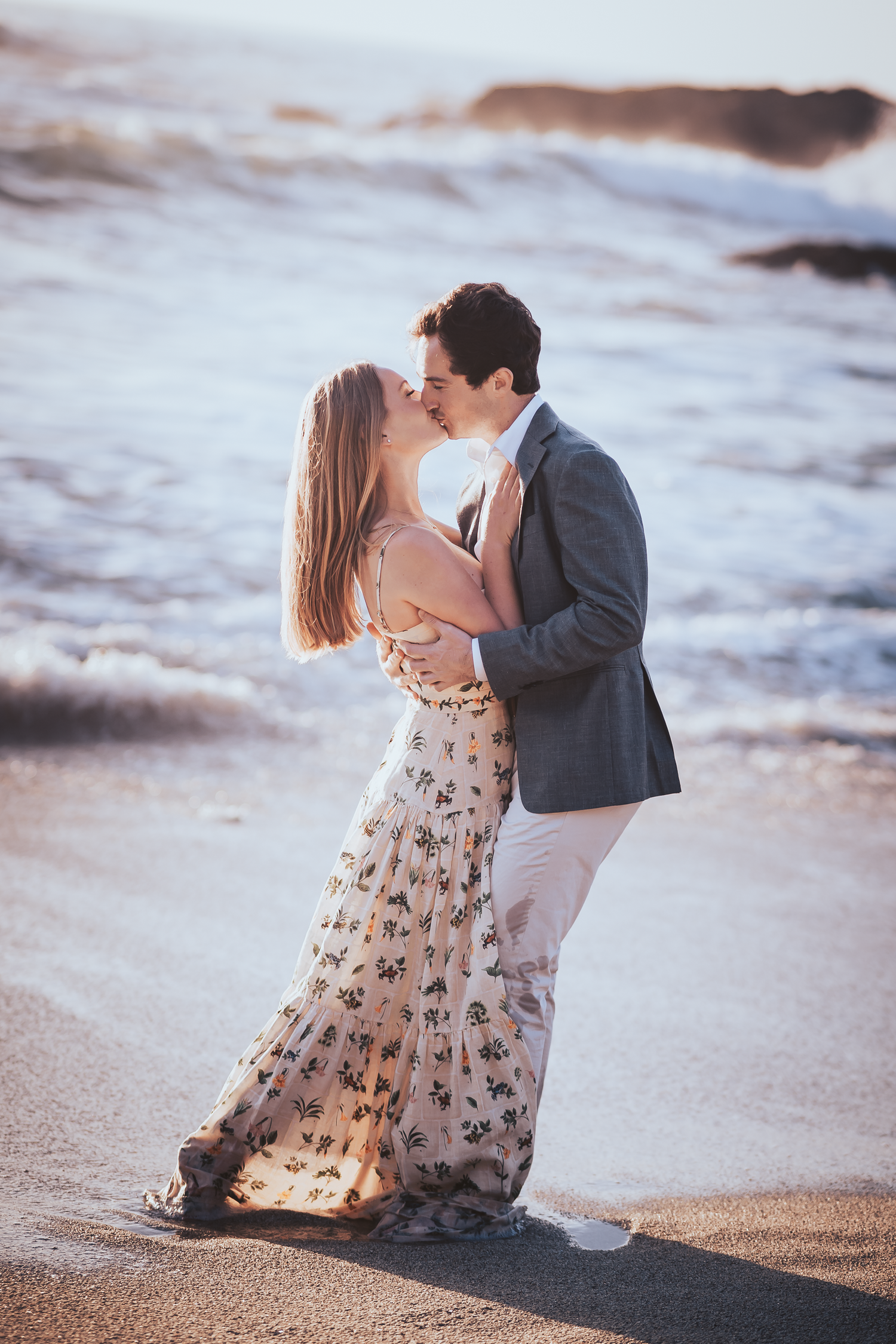 Couple sharing intimate moments on a sandy beach during golden hour at Bodega Bay in Sonoma County