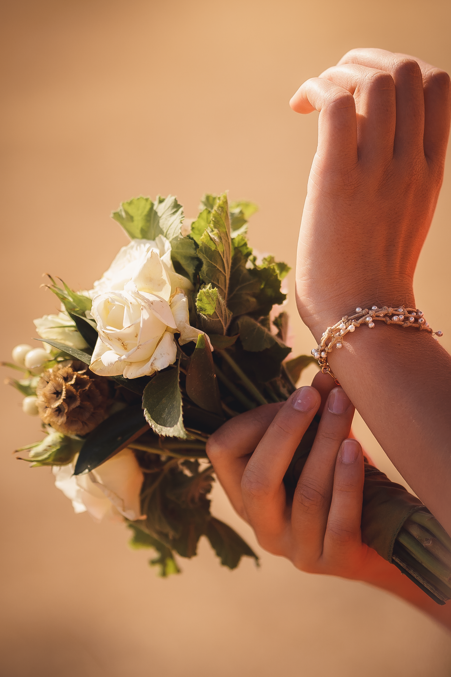 Close-up of delicate white rose corsages and floral decorations on wrists at Cow-Track Ranch in Marin County.