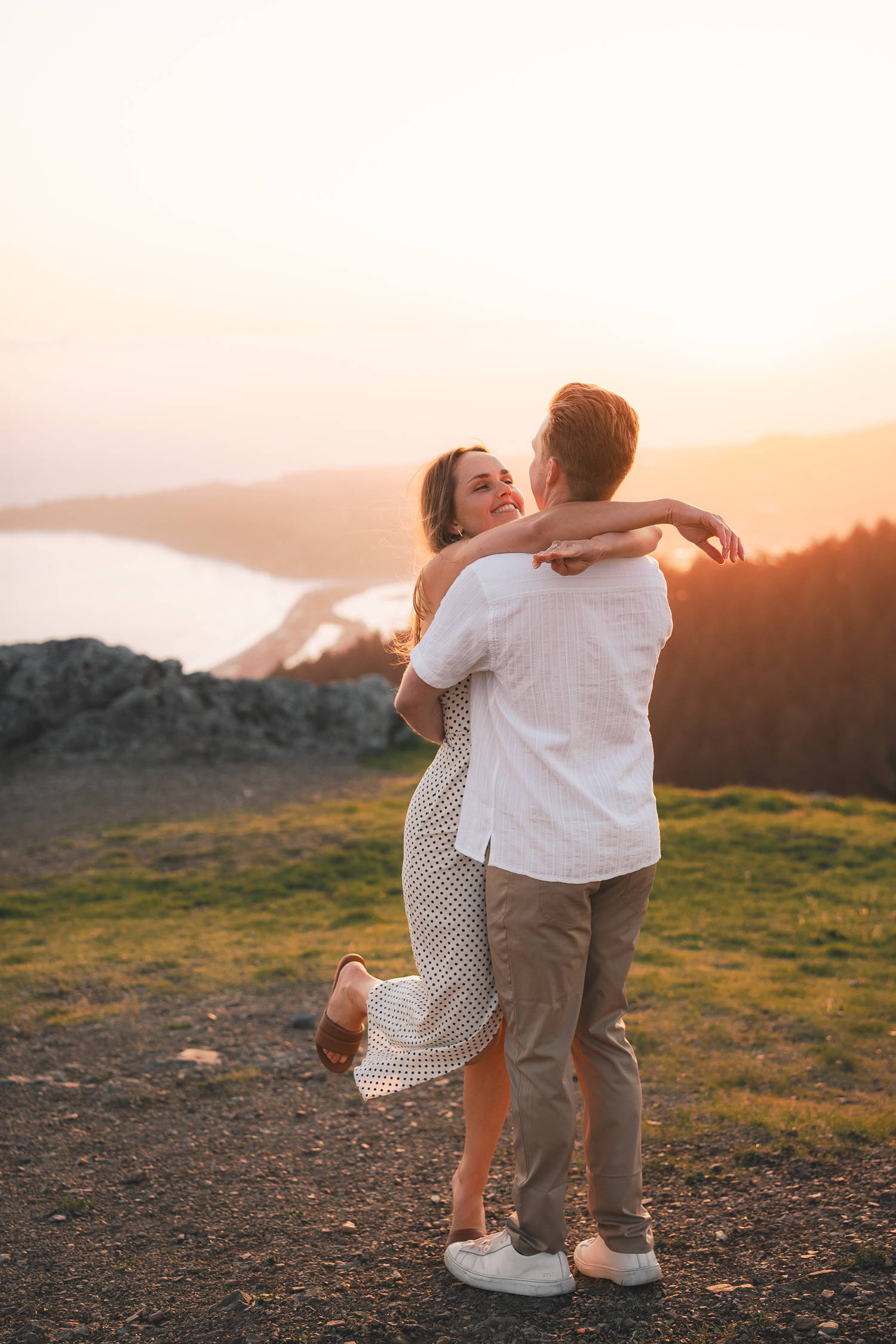 A romantic sunset embrace on a hilltop overlooking a scenic mountain landscape on Mount Tamalpais in Marin County.