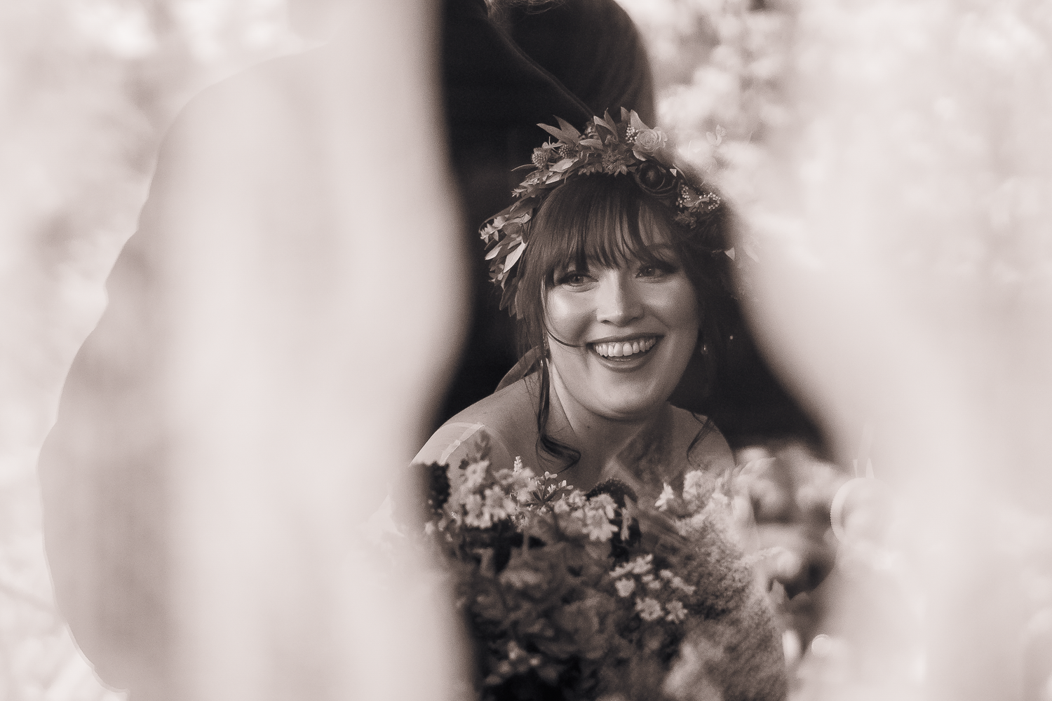 Candid black and white portrait of bride showing joyful laughter and celebration.