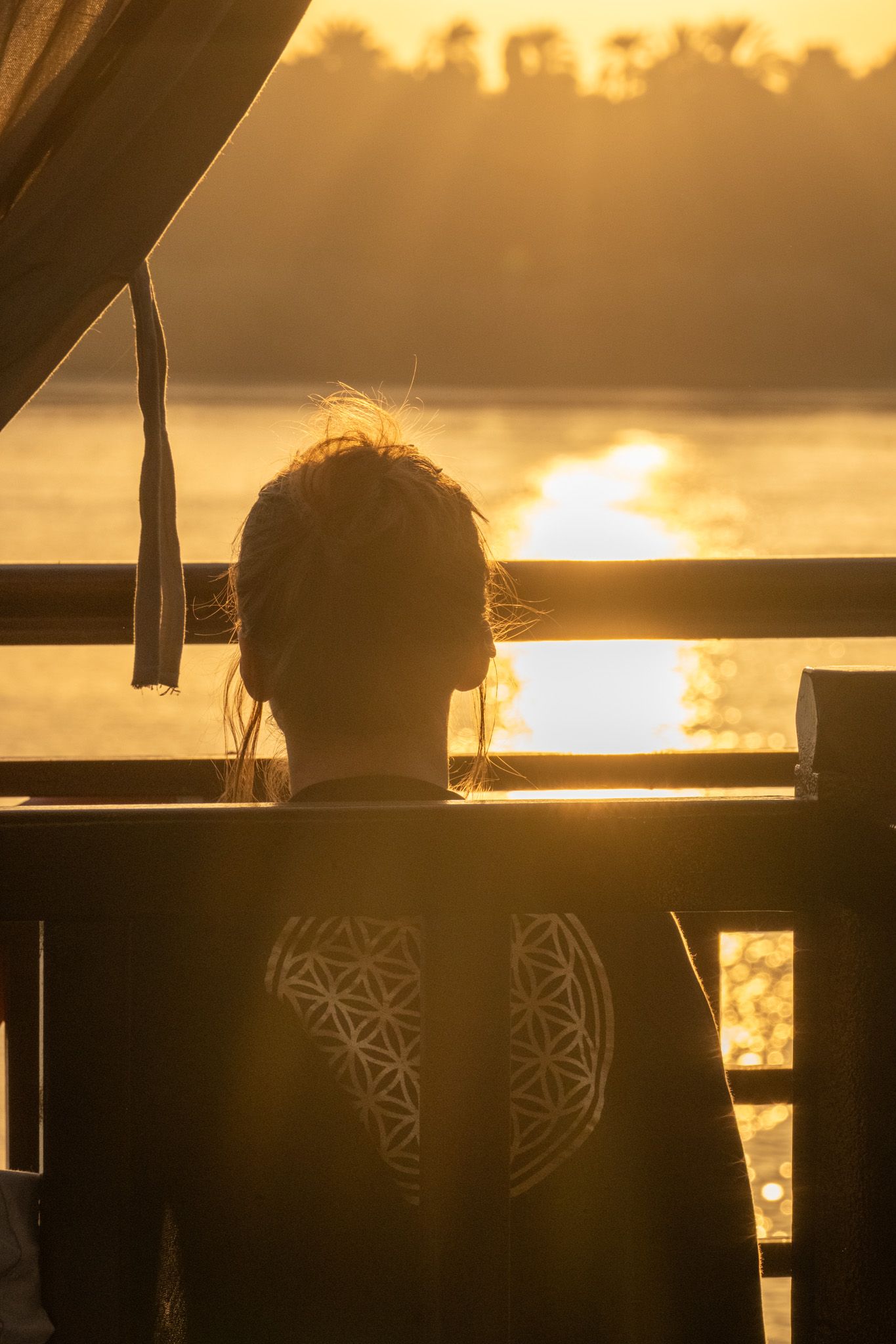 Silhouettes against golden sunset sky with decorative patterns visible in background.