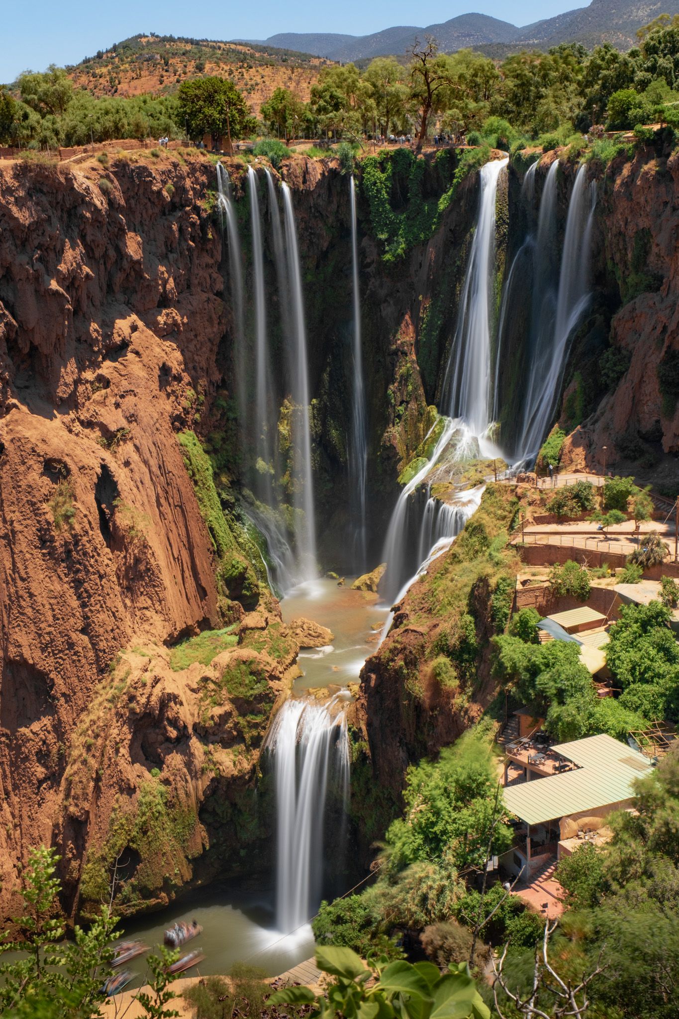 Spectacular multi-tiered Ouzoud waterfalls cascade down red cliffs in Morocco.