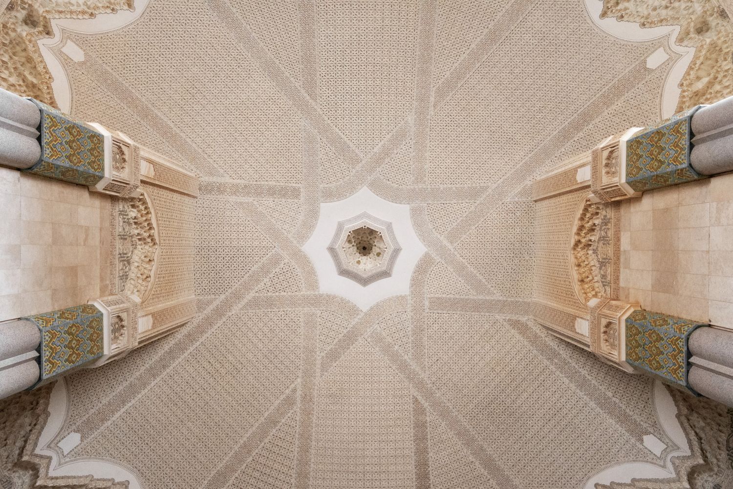 Ornate vaulted ceiling with intricate geometric patterns viewed from directly below in Islamic architecture.