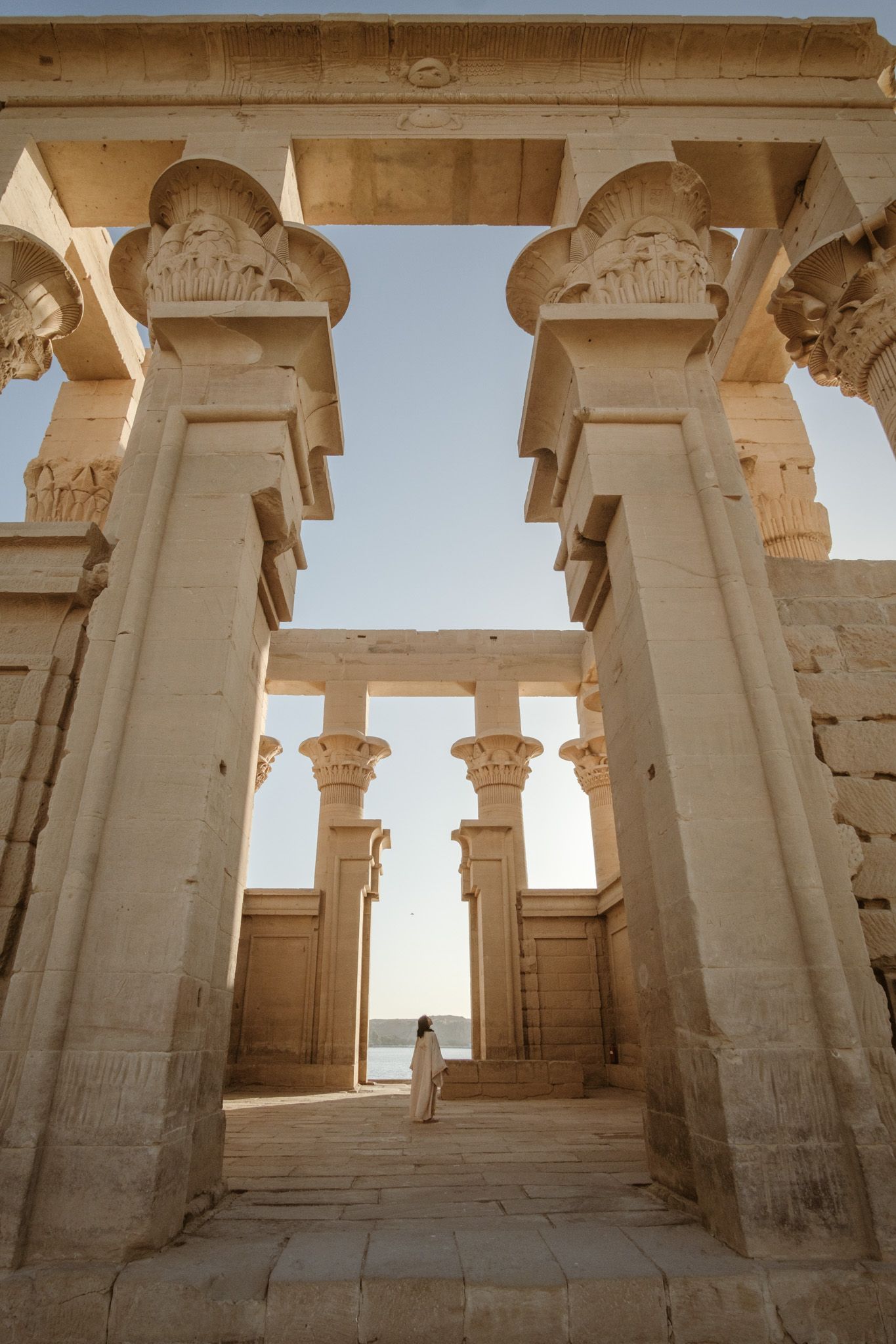 Ancient Egyptian temple interior with massive stone columns and ornate capitals.