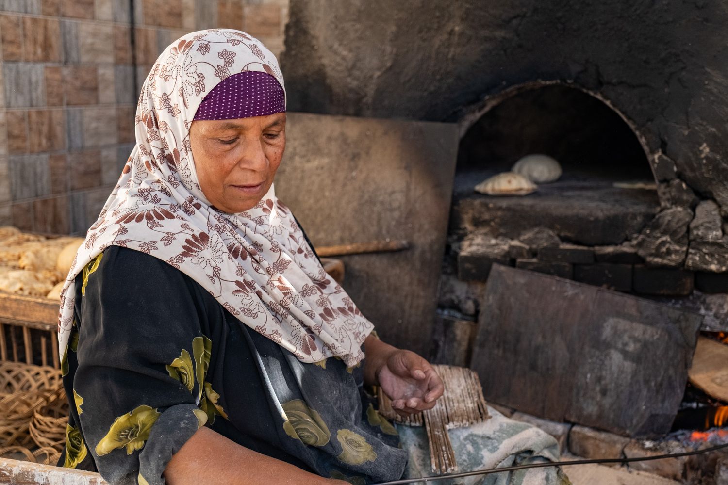 Traditional bread making scene at a stone oven in Morocco.