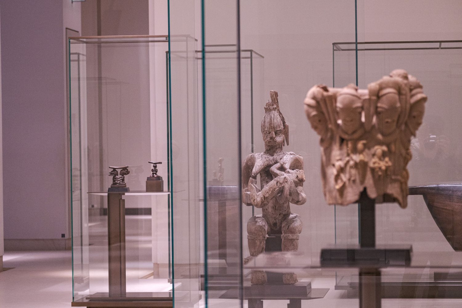 Ancient sculptures and artifacts displayed in glass museum cases.