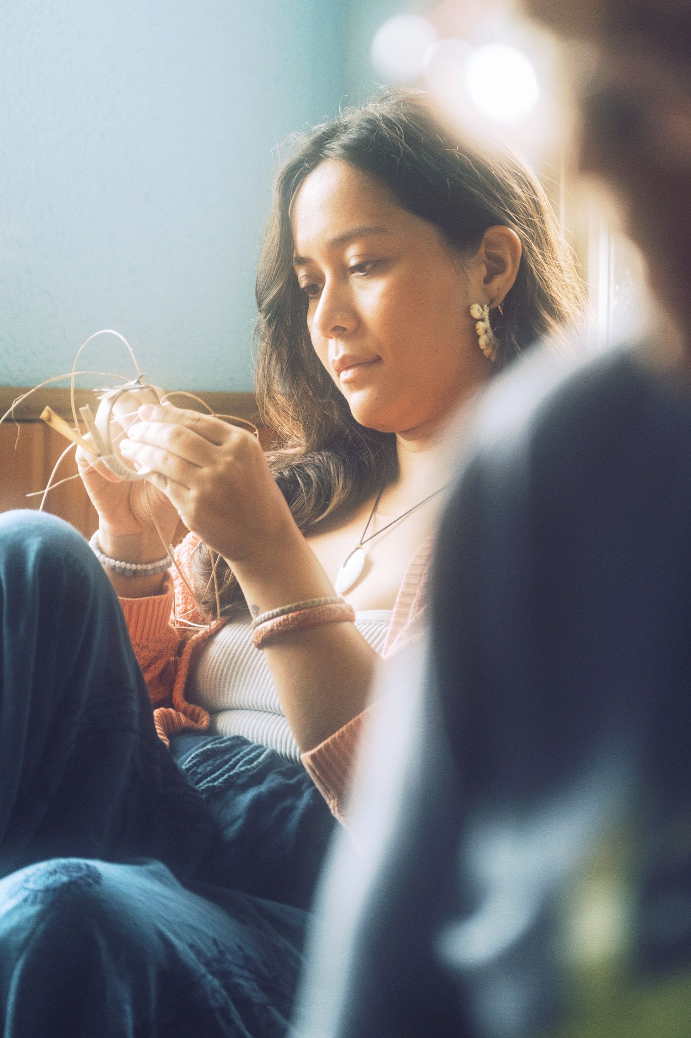 Soft focus portrait of person holding string lights in a dreamy atmospheric setting.